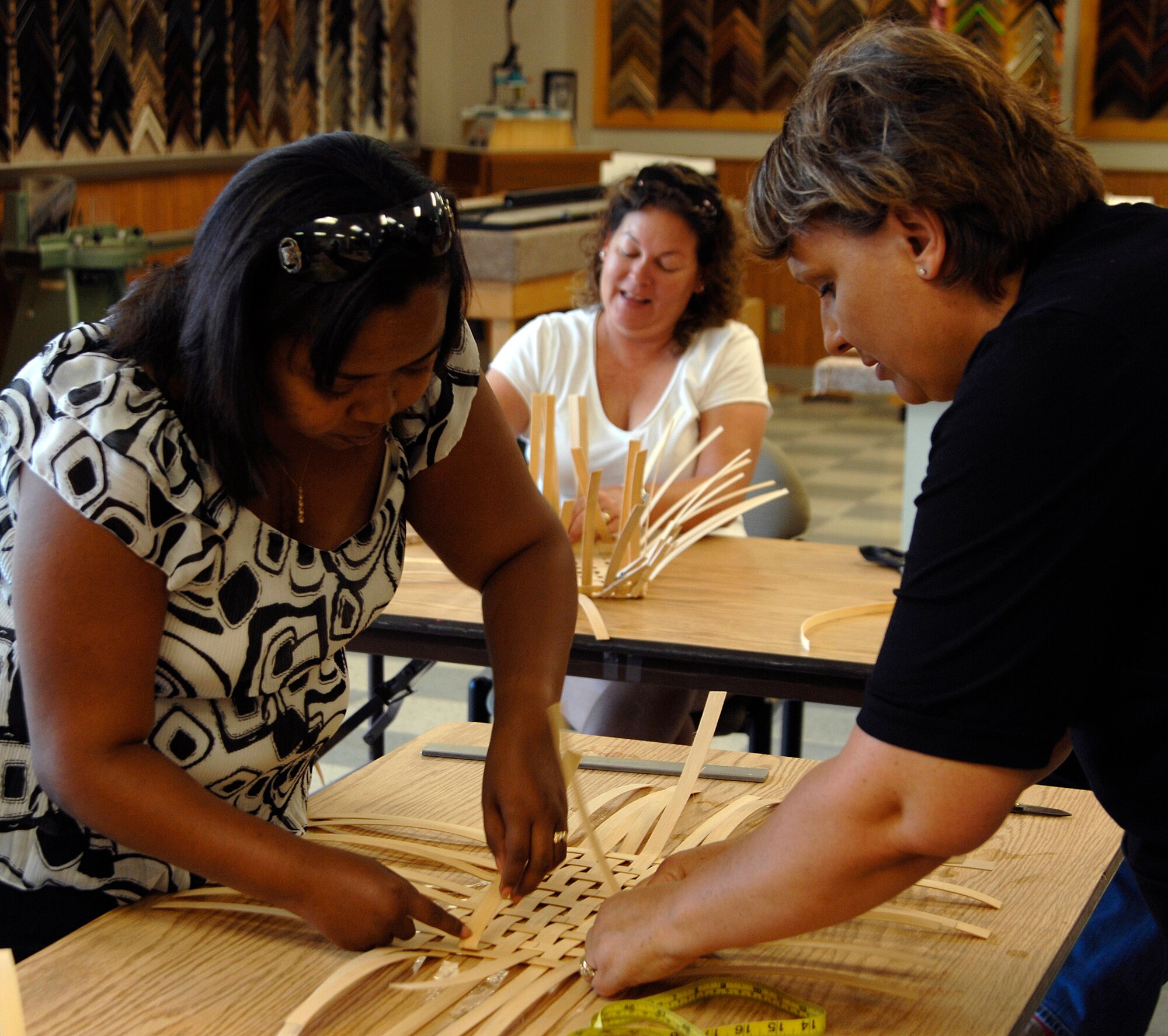 MCCONNELL AIR FORCE BASE, Kan. -- Marquita Cyphers, left, receives help from Teresa Eftink, right, base arts and crafts director, while weaving a basket as a craft project for the Adult Summer Reading program sponsored by the base library, July 11. This event was held at the base Arts and Craft Center; for more information on projects like this, please contact 759-4084. (Photo by Senior Airman Laura Suttles)