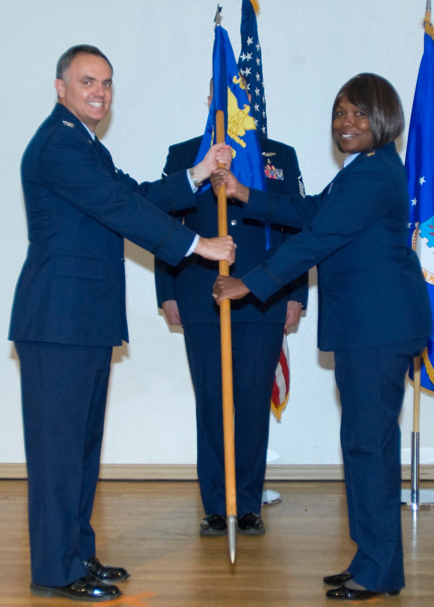 Col. Darrell Riggs, 95th Mission Support Group commander, passes the 95th Force Support Squadron guidon to Maj. Susie Lewis, as she assumes command of the squadron July 10. (Air Force photo/Heather Anhalt)