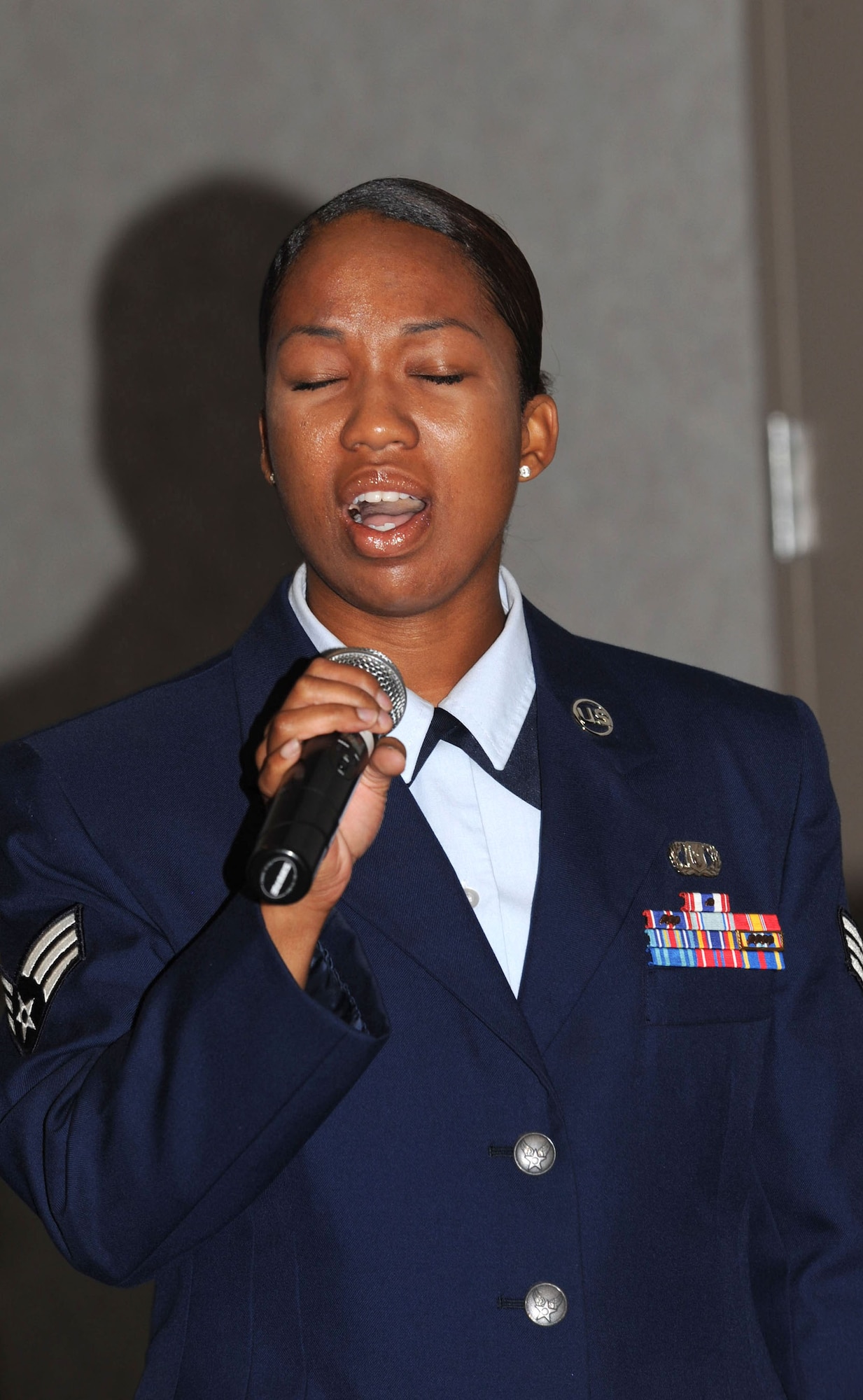MCCONNELL AIR FORCE BASE, Kan. -- Senior Airman Anisah Lavine, First Term Airman Center Team Leader, sings the National Anthem at Col. Michael Dillard, former Maintenance Group commander’s retirement. Colonel Dillard retired from the Air Force after 30 years of service. (Photo by Tech. Sgt. Chyrece Campbell)