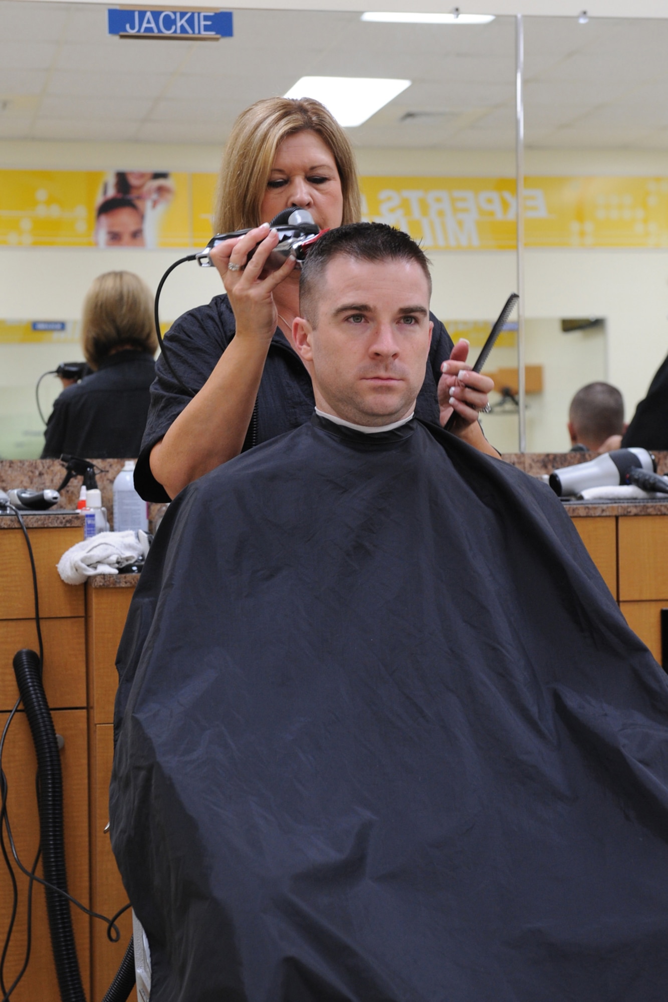 Jackie Farmer, Army & Air Force Exchange Service barber, cuts the hair of Capt. Mark Colwell, 916th Air Refueling Wing mission developer, at the Base Exchange barber shop on Seymour Johnson Air Force Base, N.C., July 10, 2009. Mrs. Farmer is a retired military spouse who enjoys making military members and their families look good. (U.S. Air Force photo by Airman 1st Class Whitney S. Lambert) 