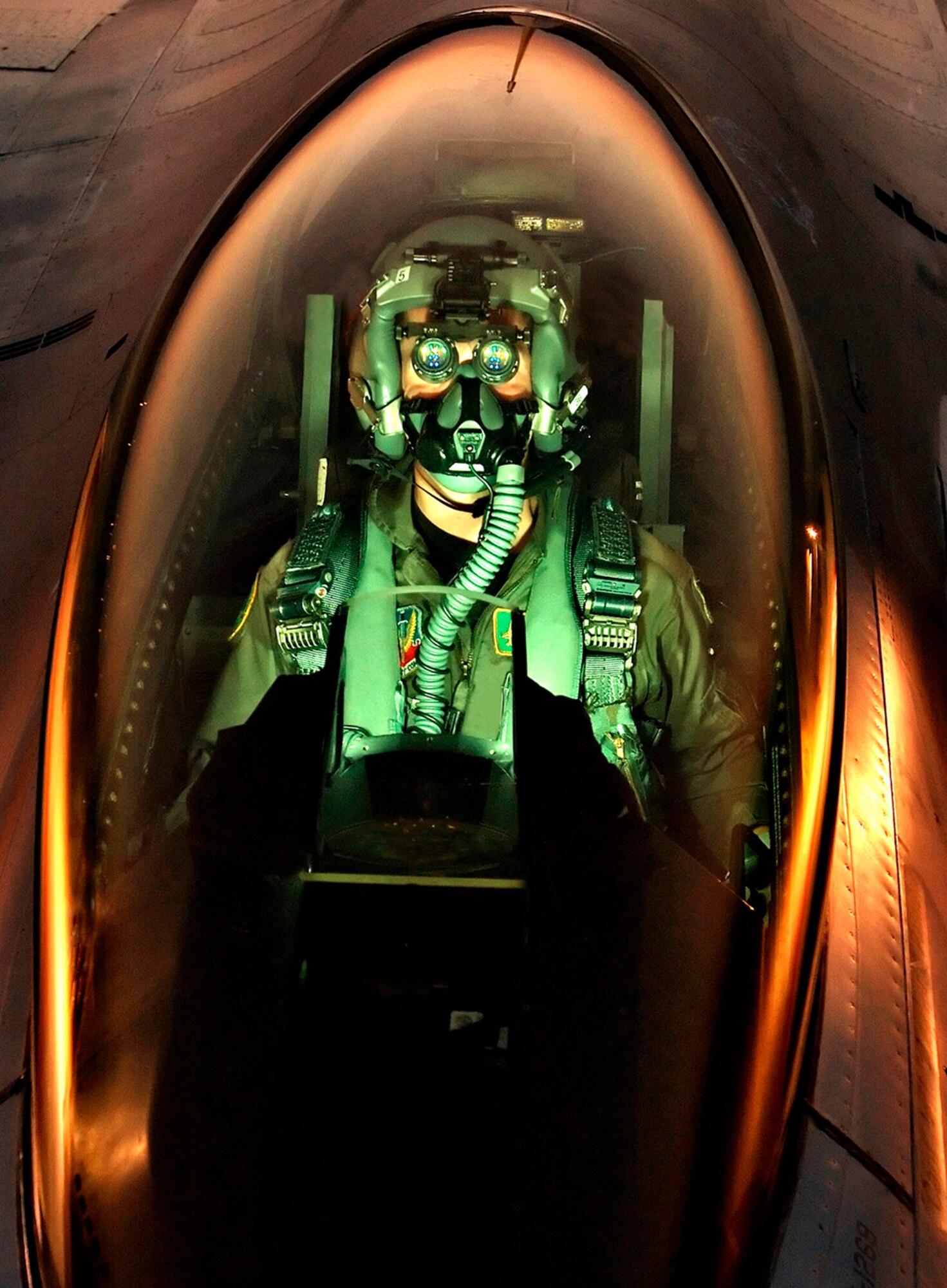 1st Lt. "Sqwirll" (full name withheld) an F16 pilot with the Vermont Air National Guard peers through his night vision goggles. (RELEASED) Photo by Master Sgt. Rob Trubia