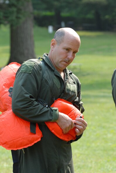 Senior Master Sgt. Raymond Lavalee deflates his personal floatation device after water survival training. Lavallee, a loadmaster, and other flight crew members of the 193rd Special Operations Wing, located in Middletown, Pa., went to a lake in Mount Gretna, Pa., for their water survival training on July 11, 2009.