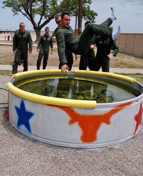 LAUGHLIN AIR FORCE BASE, Texas -- Second Lt. Bryan Trottier, 84th Flying Training Squadron, is thrown into a pool by his classmates in celebration of his first solo flight during Specialized Undergraduate Pilot Training here recently. The dunking of the pilot after his first solo flight is one of many long-running traditions in military pilot training. (U.S. Air Force photo by Airman 1st Class Sara Csurilla) 