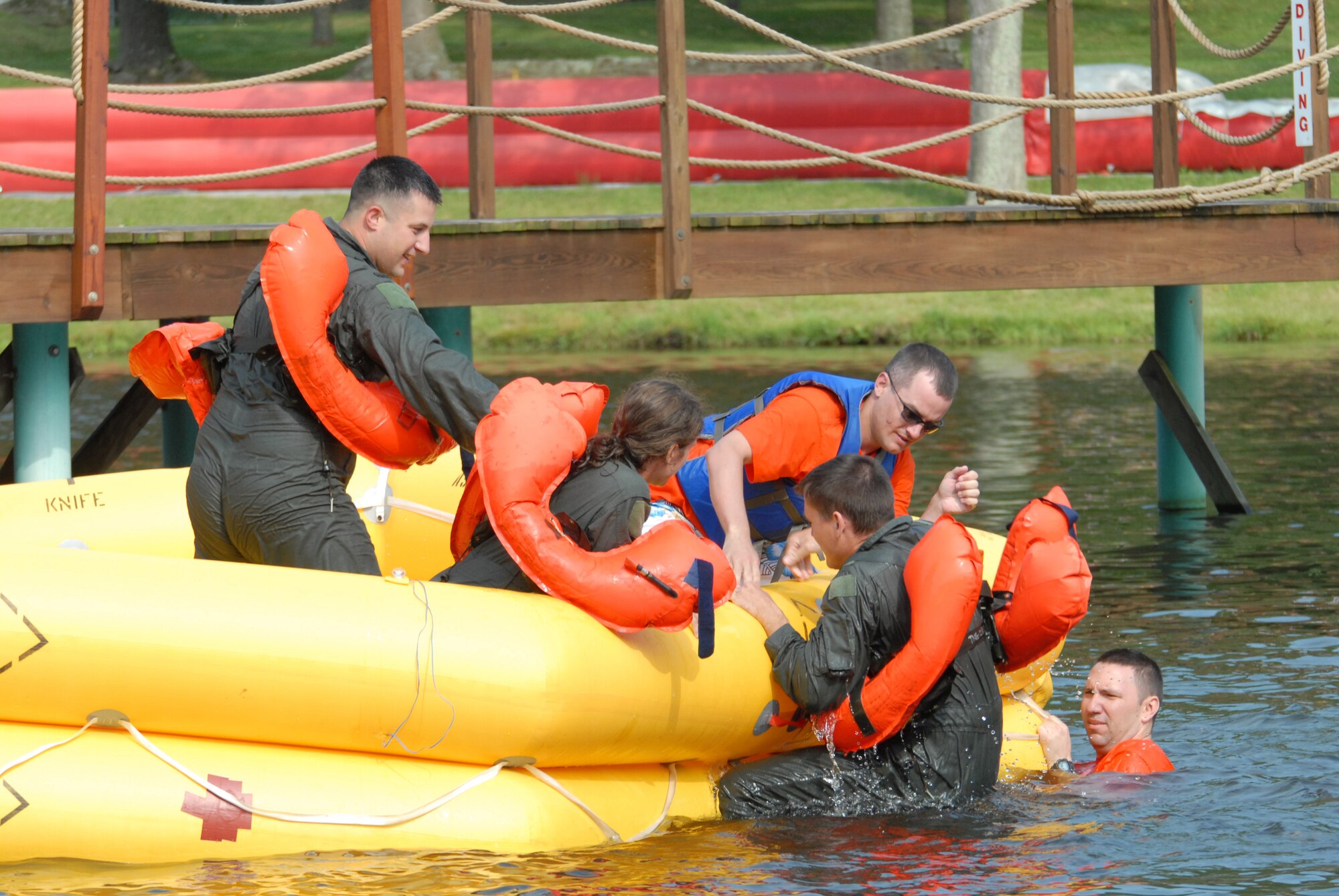 Tech. Sgt Pete Loree, an arcrew flight equipment technician of the 193rd Special Operations Wing, helps a flight crew member of the 193rd SOW aboard a 46-man life raft. This was part of the water survival training held at Mount Gretna Lake, Pa., on July11, 2009.