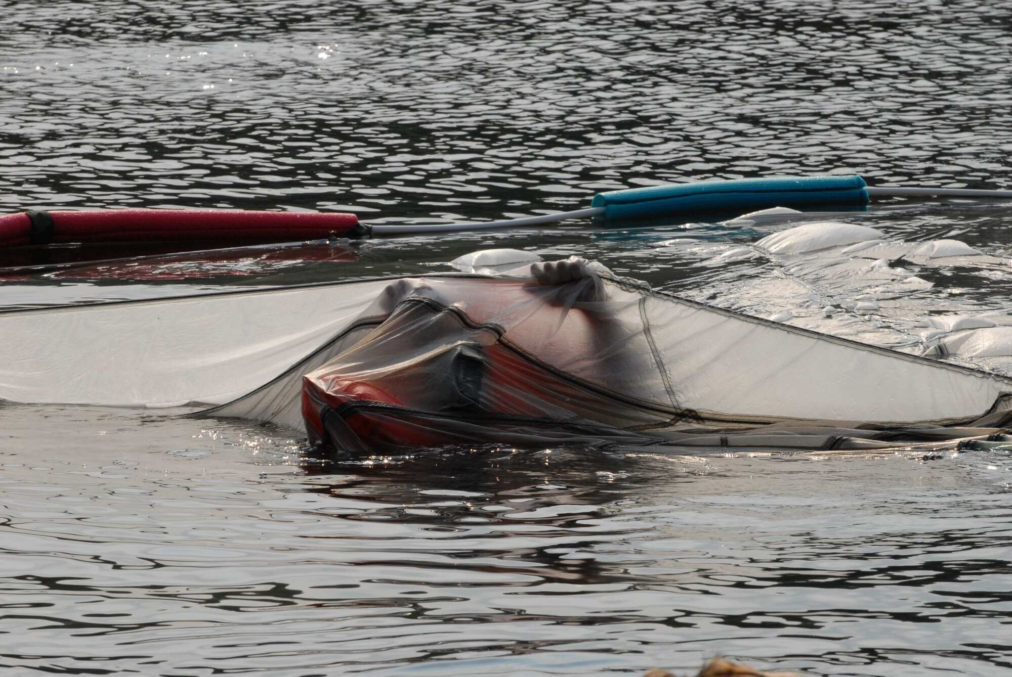 Capt. Adam Pitarra, a pilot from the 193rd Special Operations Wing, located in Middletown, Pa., finds his way out from underneath a canopy during water survival training held at Mount Gretna Lake, Pa.. This was to simulate what he would do if he had landed in the water with his parachute. Pitarra and other flight crew members of the 193rd SOW spent the morning of July 11, 2009 completing this training.
