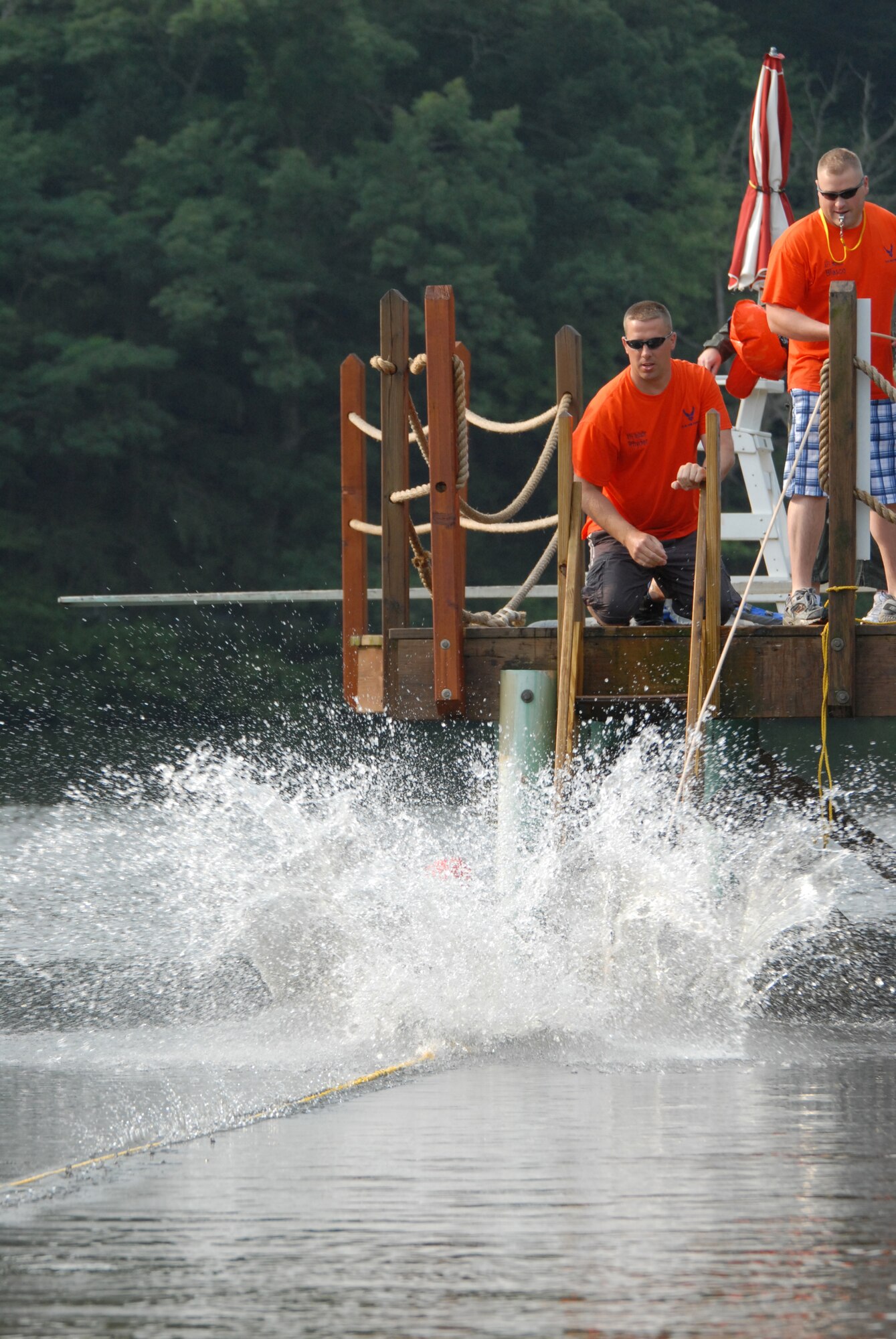 Master Sgt. Kevin Rhyder and Airman 1st Class Nathan Blasco, aircrew flight equipment technicians of the 193rd Special Operations Wing, help flight crew members of the 193rd SOW simulate what it would be like to release a parachute if caught by wind. This was part of the water survival training held at Mount Gretna Lake, Pa., on July 11, 2009.