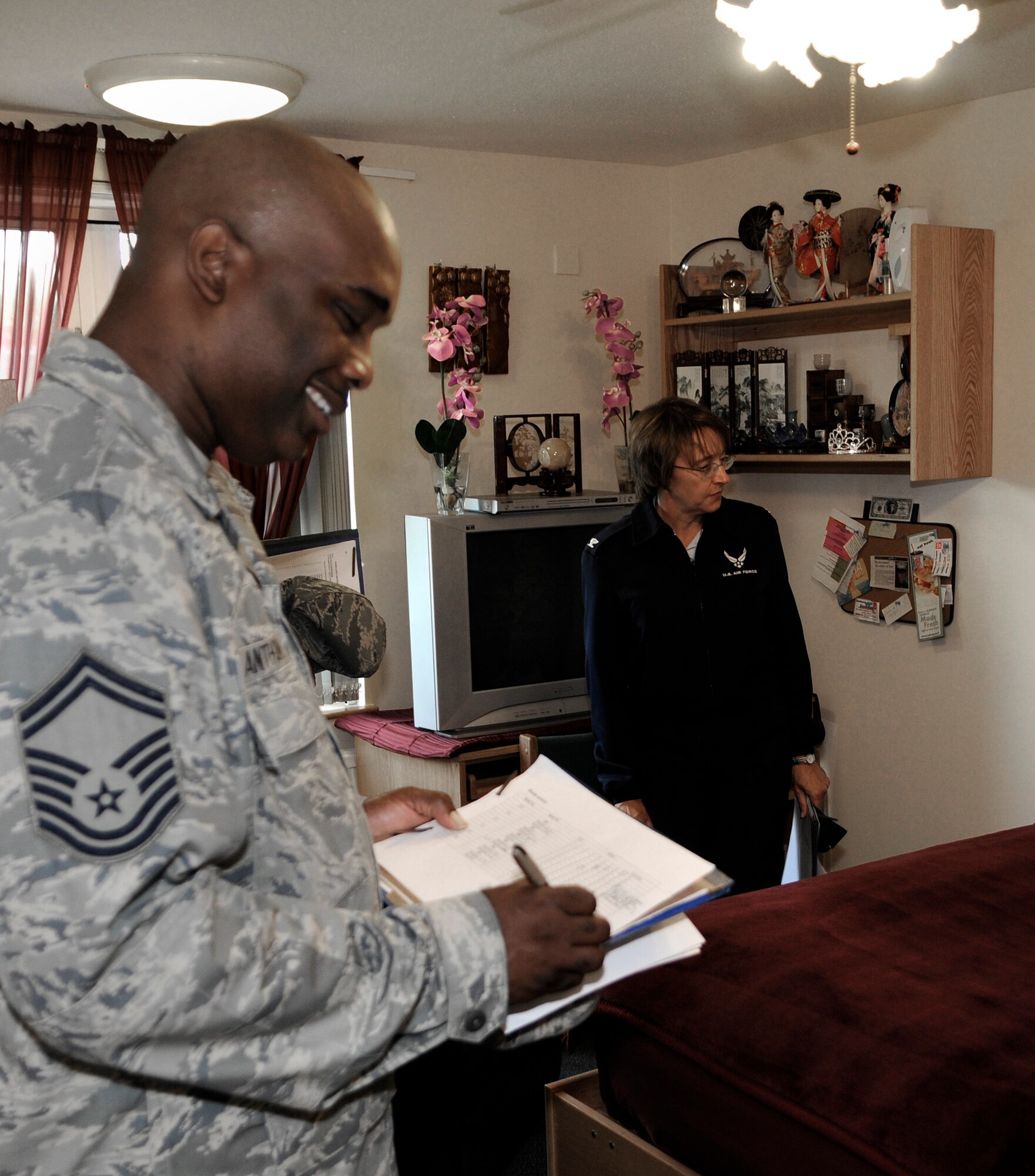 Senior Master Sgt. George Anthony (left), of the 100th Operations Support Squardron, performs a dormitory inspection with Col. Eden Murrie, 100th Air Refueling Wing commander, during the quarterly Dorm of the Quarter competition July 14 in the room of Senior Amn. Emily Rykowski. Airman Rykowski's room was nominated for Dorm Room of the Quarter for Dorm 108.  (U.S. Air Force photo by Senior Airman Thomas Trower)