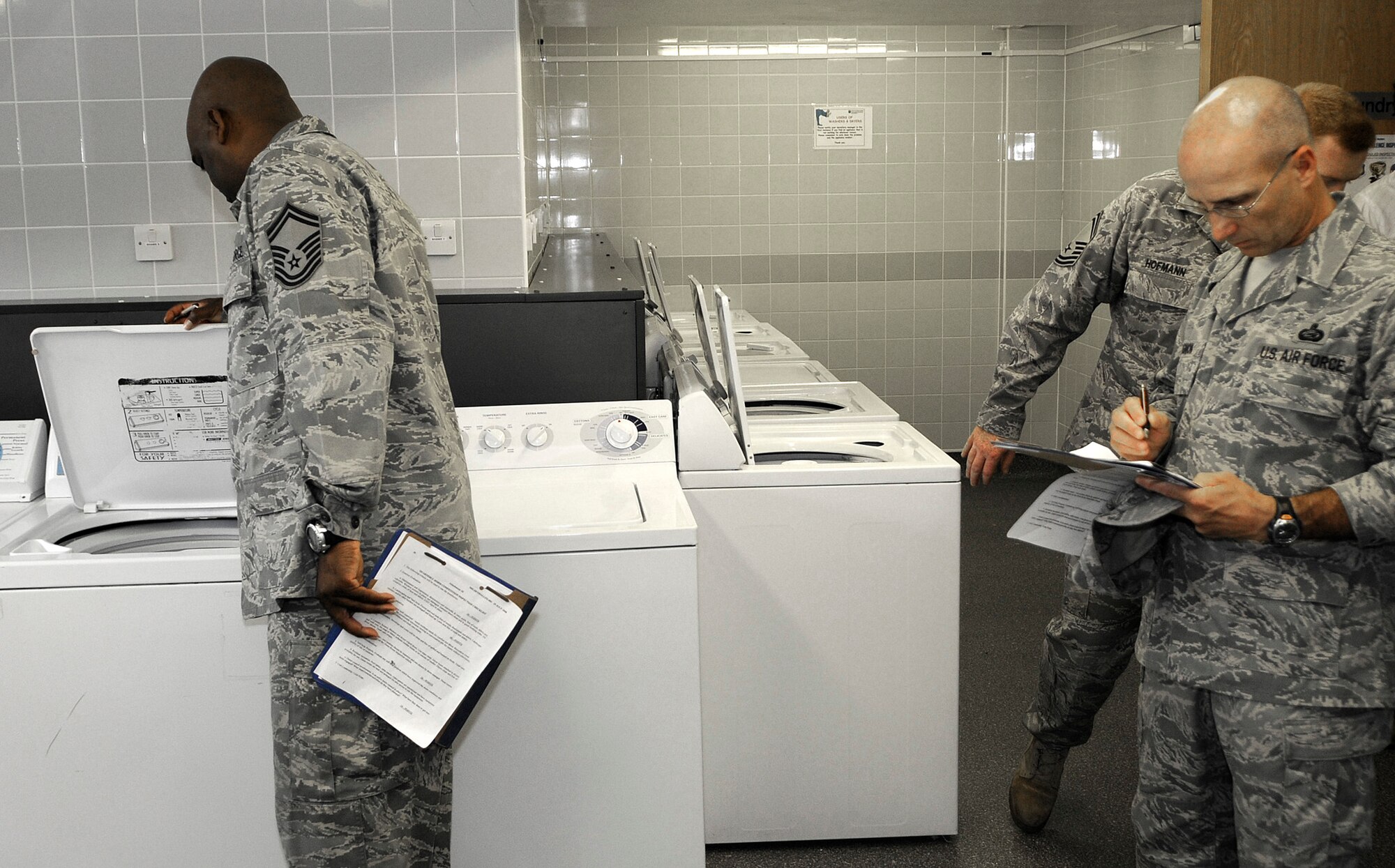 Senior Master Sgt. George Anthony (left), of the 100th Operations Support Squardron, inspects the laundry room of Dorm 107 July 14 during the quarterly Dorm of the Quarter competition.  This quarter's inspection team was headed by Col. Eden Murrie, the 100th Air Refueling Wing commander, and Chief Master Sgt. Antonio Hickey, the 100th ARW command chief. (U.S. Air Force photo by Senior Airman Thomas Trower)
