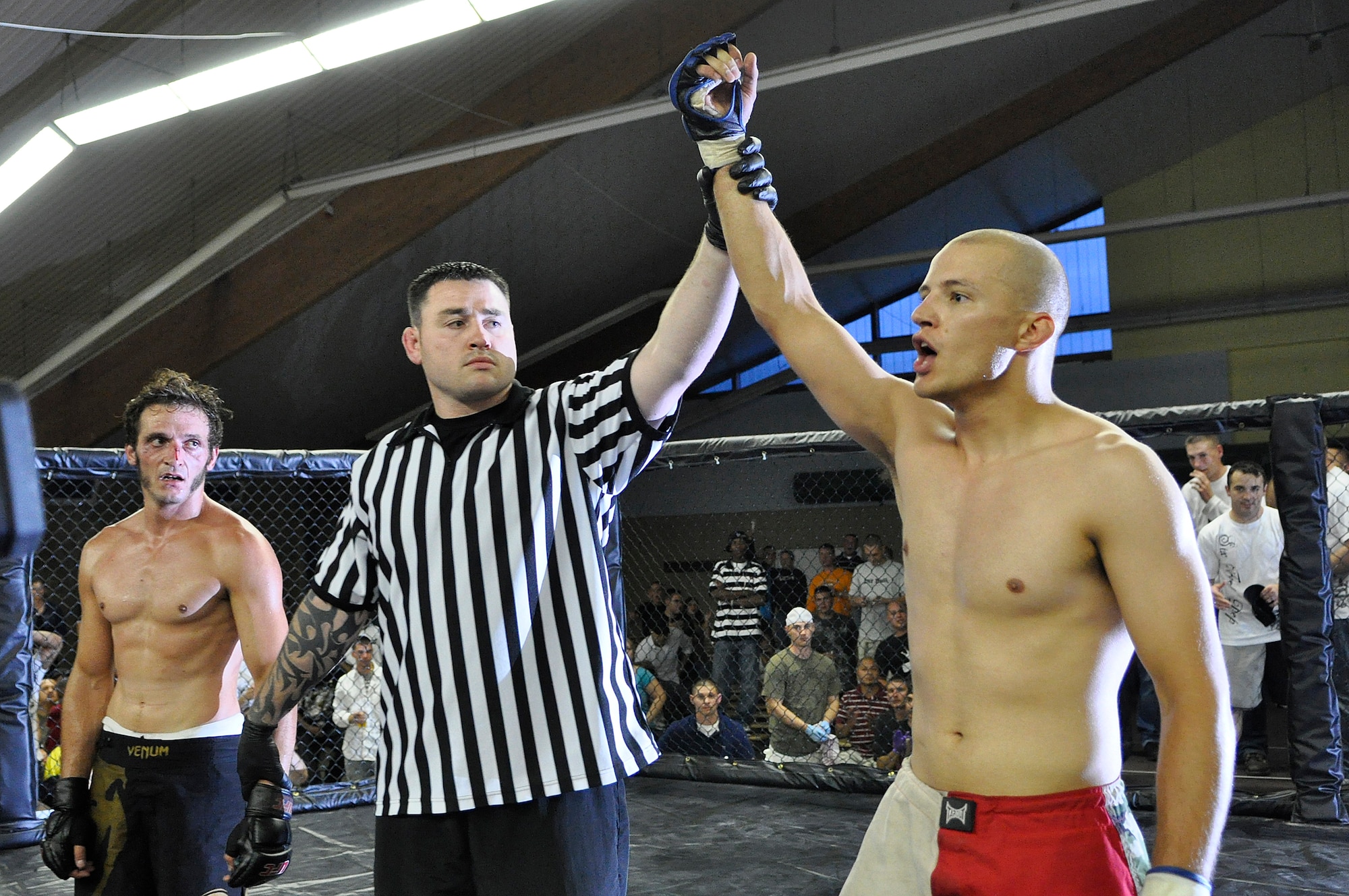 U.S. Air Force Staff Sgt. Anthony Durnell, 786th Security Forces Squadron Regional Training Center instructor, celebrates his victory over Cedric “Crazy Eyes” Jouvet of France to win the God’s of War Lightweight Championship Belt July 11, 2009, Baumholder, Germany. (U.S. Air Force photo by Staff Sgt. Stephen J. Otero)