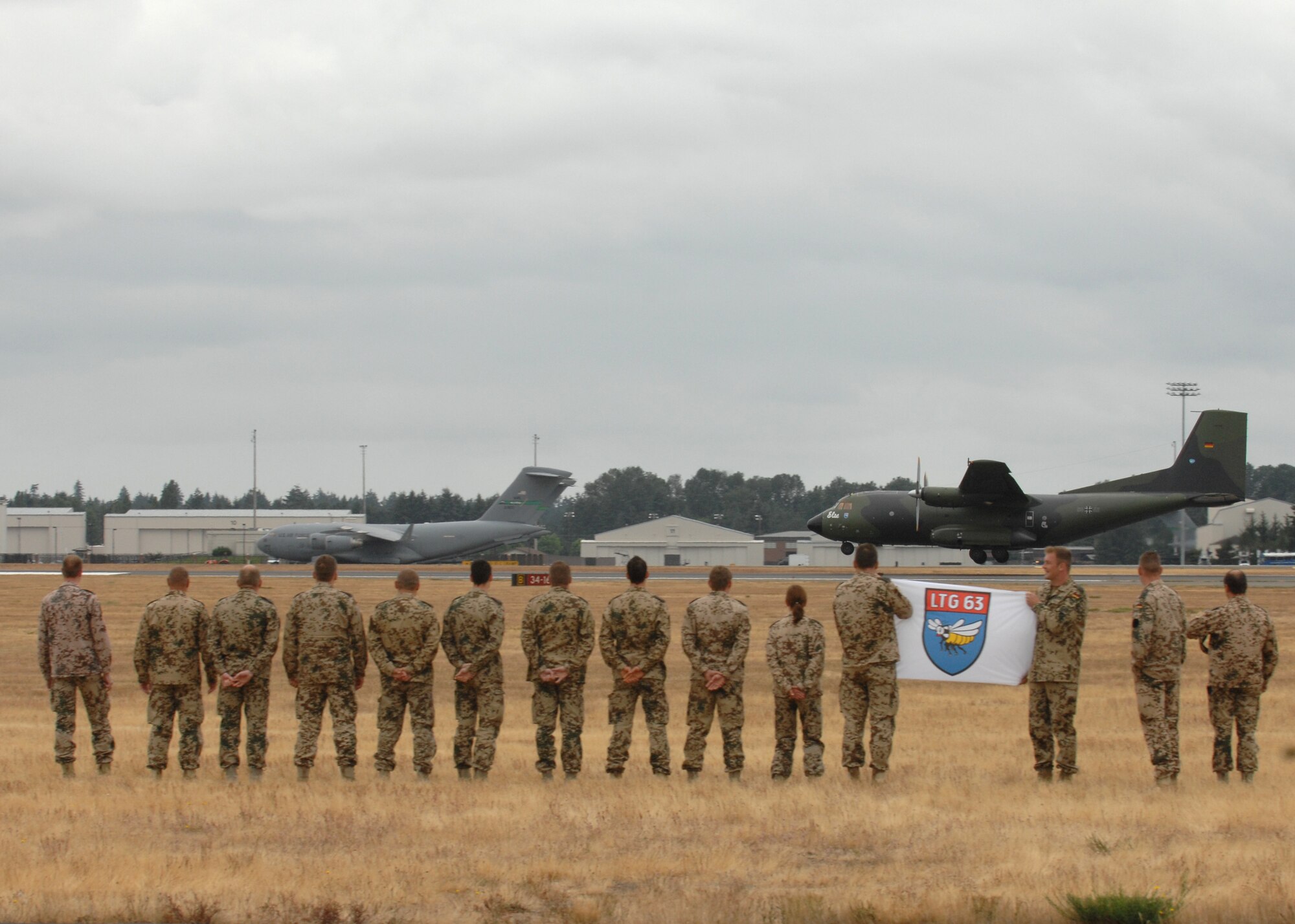 Members of the German air force watch the arrival of their C-130 aircraft and the rest of their teammates at McChord July 13, as international competitors arrive for Air Mobility Command's Rodeo 2009. (U.S. Air Force photo/Staff Sgt. Stephen Schester)