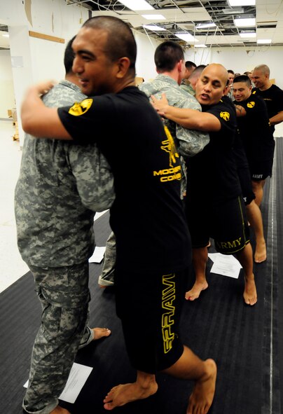 ANDERSEN AIR FORCE BASE, Guam - After a grueling hour of grappling, the Soldiers and Airmen received praise by the Modern Army Combative Training instructors here June 9. The program is designed to teach Soldiers and Airmen how to fight hand-to-hand when weapons use is not practical in a combat situation. (U.S. Air Force photo by Airman 1st Class Courtney Witt)
