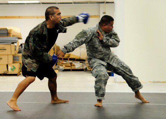 ANDERSEN AIR FORCE BASE, Guam - Staff Sgt. Jason Pablo, 254th Guam Air National Guard flight equipment apprentice, swings a left hook at 2nd Lt. George Salan, 797th Engineering Company Guam Army Reserve, during a Modern Army Combative Training session here July 9.  The program is designed to teach Soldiers and Airmen how to fight hand-to-hand when weapons use is not practical in a combat situation. (U.S. Air Force photo by Airman 1st Class Courtney Witt)
