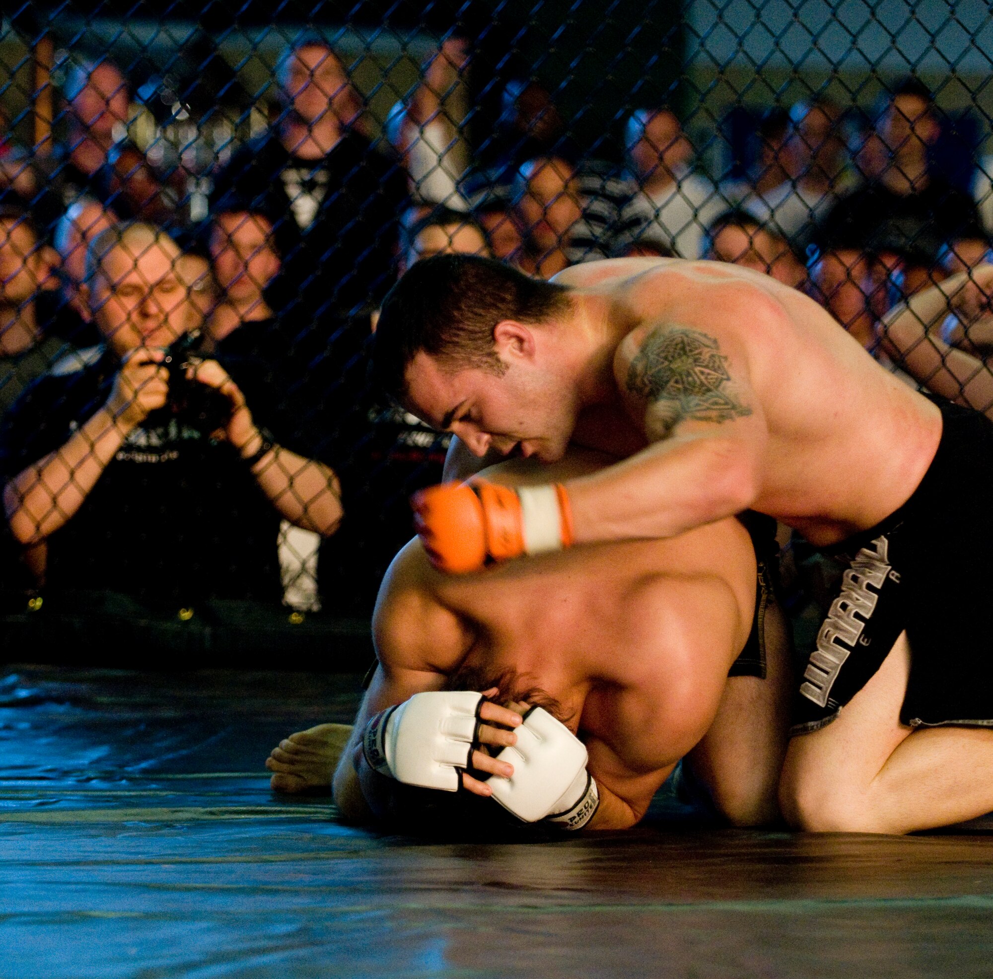 Brandon Kilfoyle of Team Catacomb delivers strike after strike on the back of Benjamin Cigliutto of France, giving him the win with a technical knockout in 3 minutes and 19 seconds in the first round of his debut fight, July 11, 2009, Baumholder, Germany.  Kilfoyle is a staff sergeant with the 786th Security Forces Squadron at Sembach Annex, Germany. (U.S. Air Force photo by Senior Airman Nathan Lipscomb)