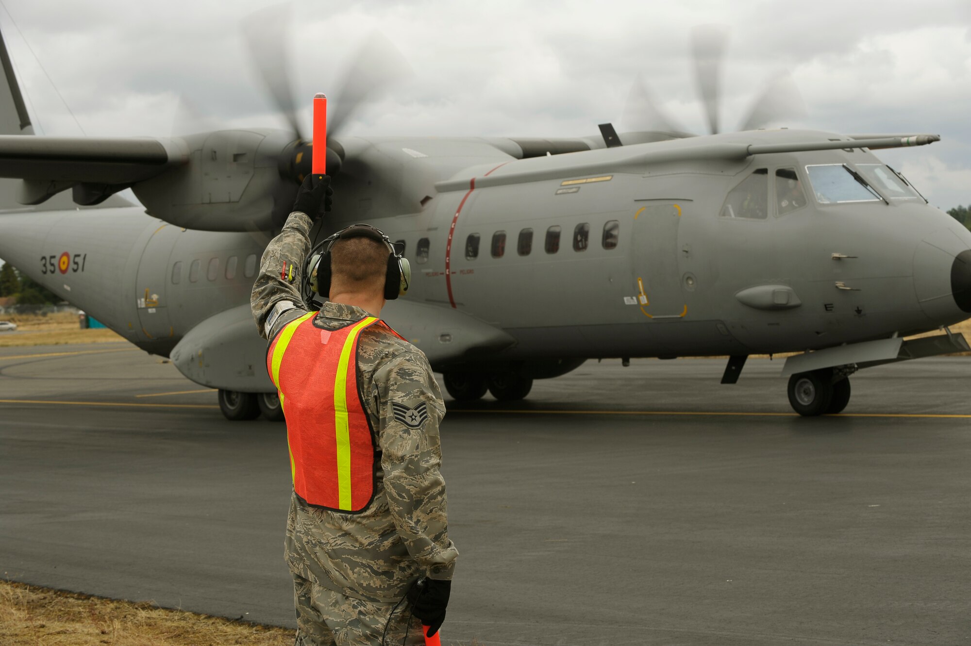 Staff Sgt. Keith Lee, 62nd Aircraft Maintenance Squadron, directs a Spanish air force C-295 aircraft into place at McChord as international competitors arrive July 13 for Air Mobility Command's Rodeo 2009. Rodeo is an international competition that focuses on improving worldwide air mobility forces' professional core abilities. (U.S. Air Force photo/Senior Airman Dayton Mitchell)  
