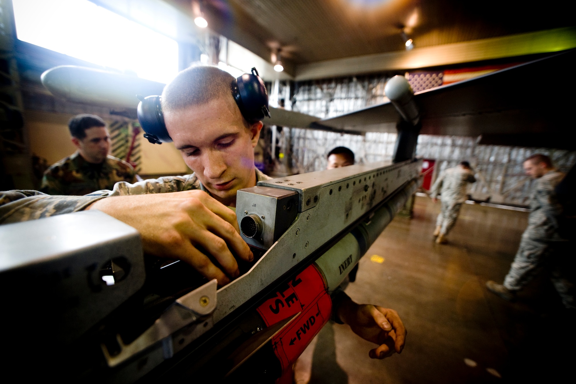 MISAWA AIR BASE, Japan -- Senior Airman Jessie Leuschel, 14th Aircraft Maintenance Unit load crew member, secures an AIM-9X heat-seeking, air-to-air missile during a weapons-load competition July 10. Aside from potentially being named the best load crew of the quarter, the crew showcased the 35th Fighter Wing's mission capabilities, while putting on a show for dozens of co-workers and guests. (U.S. Air Force photo/Senior Airman Jamal D. Sutter)