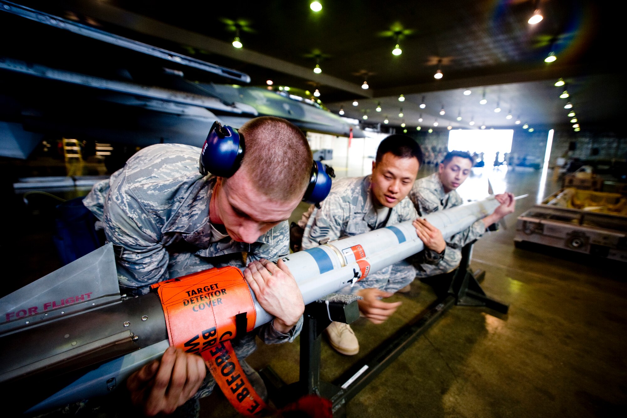MISAWA AIR BASE, Japan -- Members of a 14th Aircraft Maintenance Unit load crew prepare to lift an AIM-9X heat-seeking, air-to-air missile during a weapons-load competition July 10. The AIM-9X is also known as a Sidewinder and was named after the sidewinder snake, which detects its prey via body heat. (U.S. Air Force photo/Senior Airman Jamal D. Sutter)