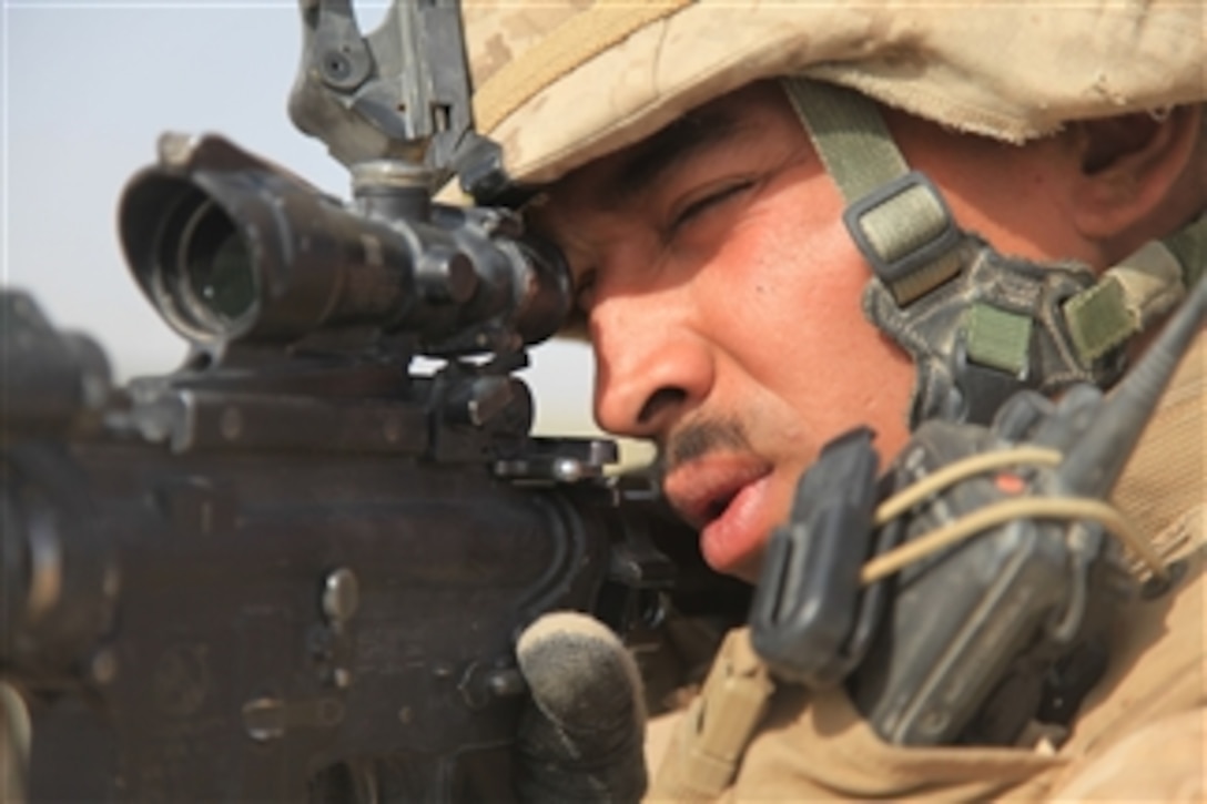 U.S. Marine Corps Sgt. Raphi Mercado, with India Battery, 3rd Battalion, 11th Marine Regiment, scans the area outside Fire Base Fiddler's Green, Afghanistan, while awaiting a resupply airdrop on July 5, 2009.  The Marines are deployed to support NATO's International Security Assistance Force and will participate in counter insurgency operations.  They will train and mentor Afghan National Security Forces to improve security and stability in the country.  