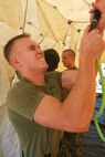 Sgt. Scott McCague, decontamination team leader, Company A, Chemical Biological Incident Response Force, II Marine Expeditionary Force, attaches a water hose to the decontamination tent during a training exercise at the McMillan Water Treatment Facility in Washington D.C., July 15, 2009.  Casualties from a high-yield explosive incident are decontaminated and at this location. Corpsmen and medical officers respond to chemical, biological, radiological, nuclear, and high-yield explosive incidents with CBIRF Marines and provide medical care in the contaminated area.