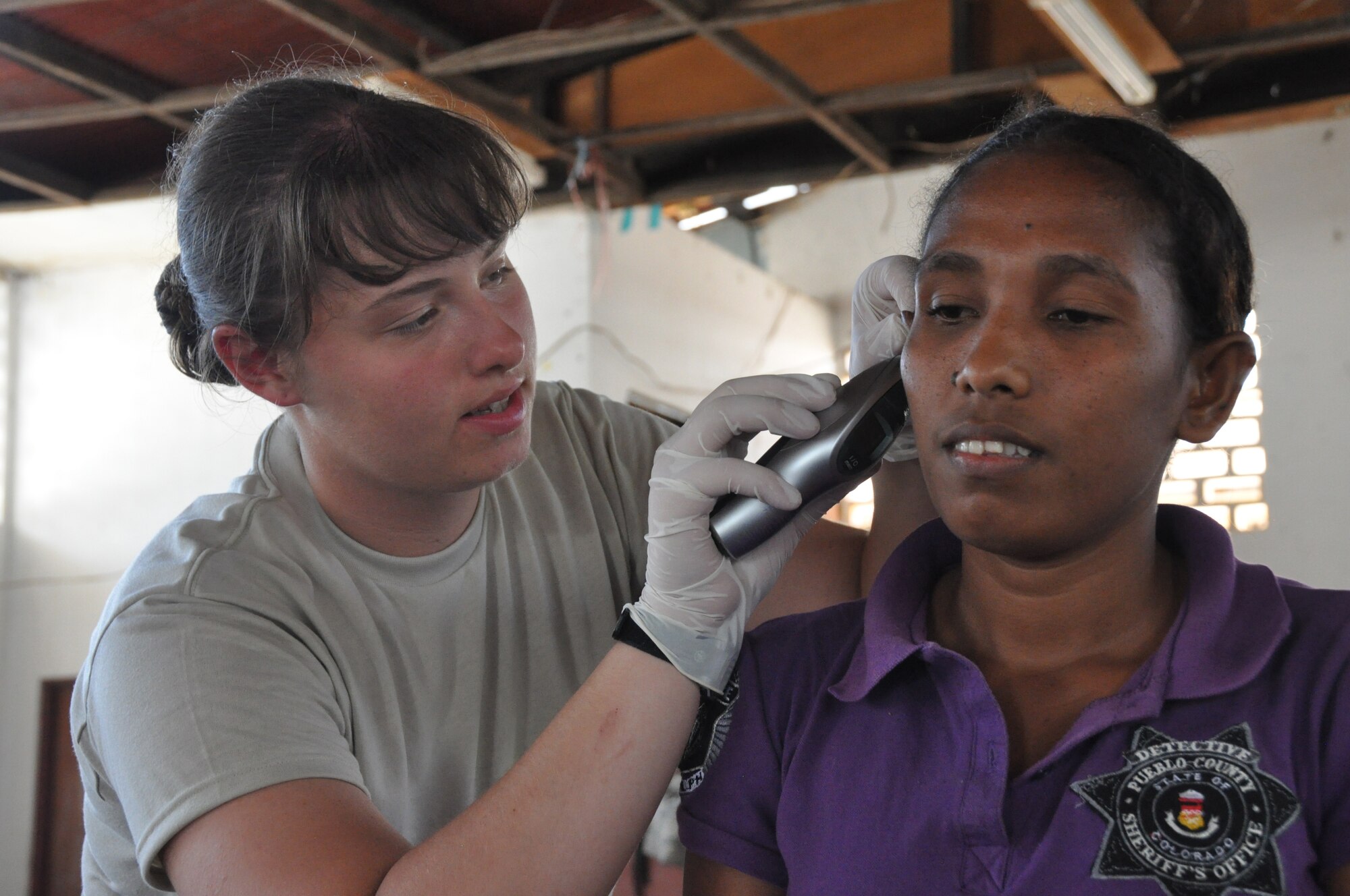 Senior Airman Ashley Cope conducts an ear exam on an East Timorese woman during inprocessing procedures at a clinic in Dili, Timor Leste, July 16. Airman Cope is assigned to the 3rd Medical Group at Elmendorf Air Force Base, Alaska, as a labor and delivery technician. East Timorese and U.S. officials set up the clinic as part of Operation Pacific Angel 2009, a Pacific Air Forces humanitarian assistance operation led by 13th Air Force at Hickam AFB, Hawaii. (U.S. Air Force photo/Tech. Sgt. Cohen A. Young)