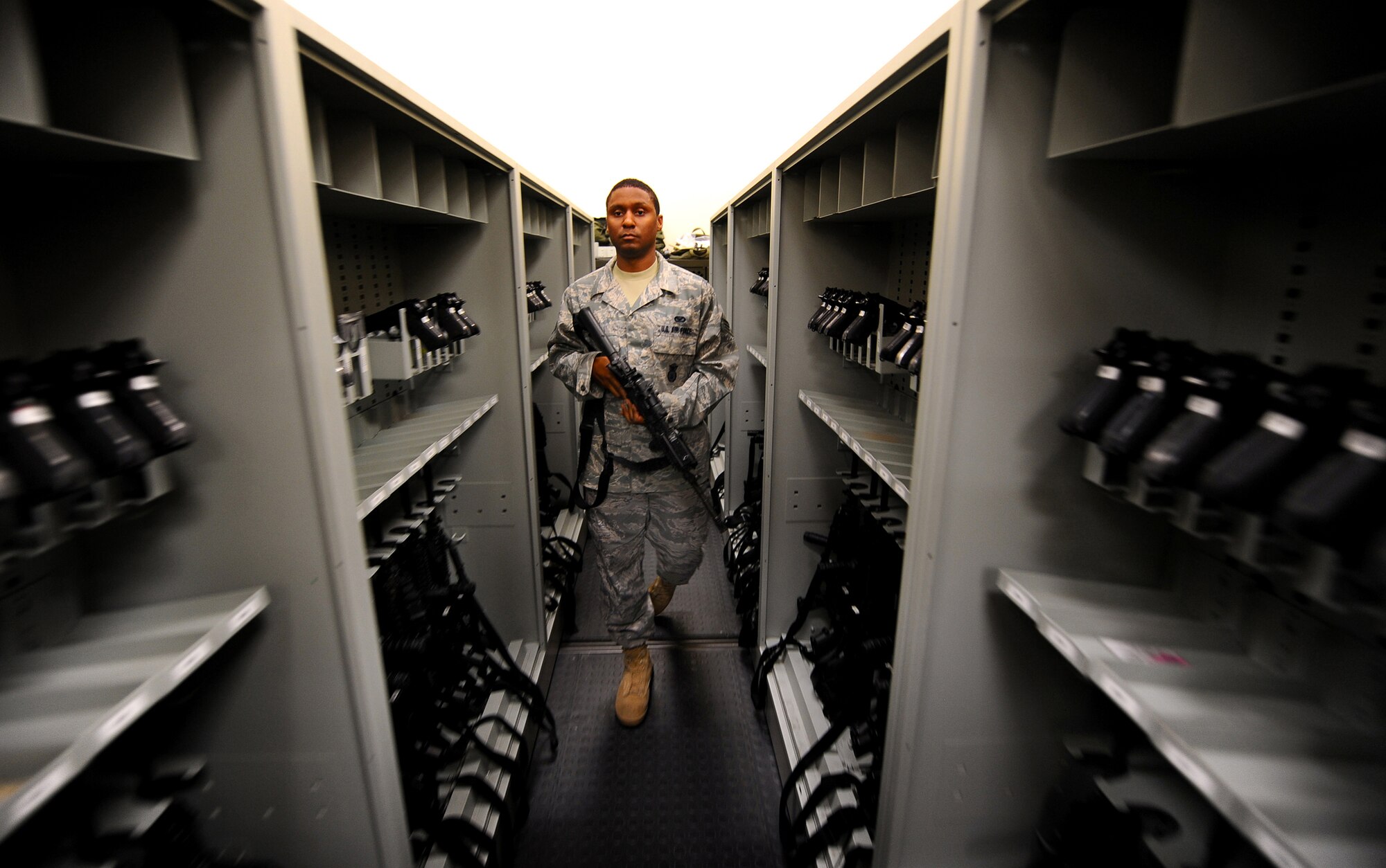 OFFUTT AIR FORCE BASE Neb. -- Senior Airman Kendrick Tibbs, an Armorer with the 55th Security Forces Squadron, retrieves an M-4 carbine rifle from a weapons rack inside the 55th SFS armory here July 14. Armorers are responsible for maintaining the integrity and reliability of weapons, ammunition and communication devices used by security forces Airmen at Offutt. U.S. Air Force Photo by Josh Plueger
