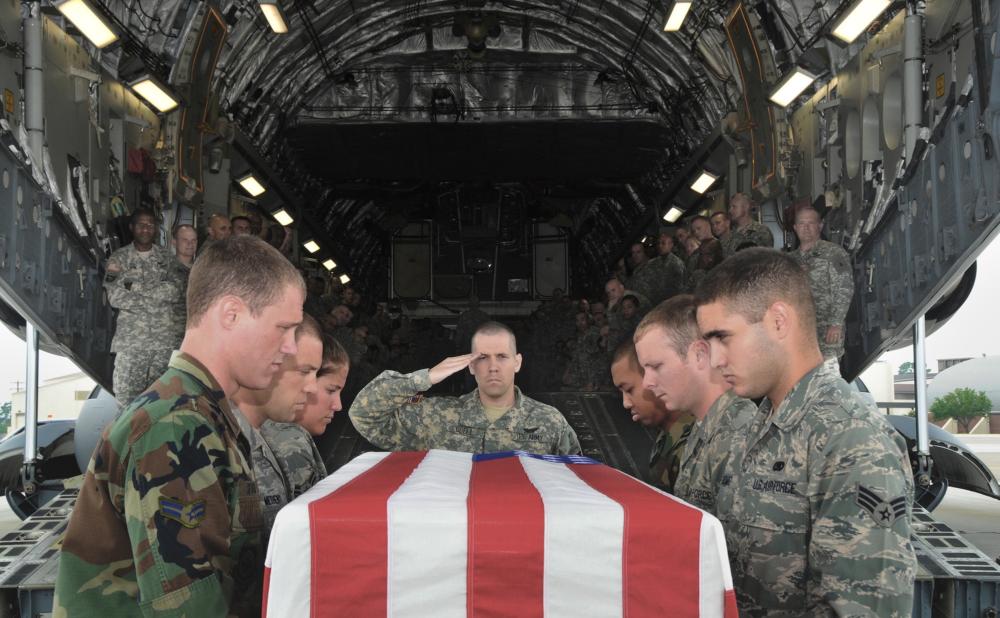 Army Chap. (Capt.) Joseph Odell salutes as a U.S. flag draped transfer case is prepared to be carried aboard a C-17 Globemaster III by Charleston Air Force Base honor guard members on the flightline during training for dignified transfers of human remains July 14 at Charleston AFB, S.C. More than 170 Army chaplain candidates traveled to Charleston AFB from Fort Jackson, S.C., to take part in the the training. Chaplain Odell is the class leader for Chaplain Basic Officer Leader Course Class 09-002. (U.S. Air Force photo/Staff Sgt. Daniel Bowles)