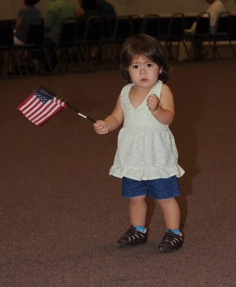 BARKSDALE AIR FORCE BASE, La. -- Delani Trussell, 14 months, daughter of Senior Airman James Trussell, 2d Security Forces Squadron, waves her flag on the first note of the National Anthem being played by the Shreveport Metropolitan Concert Band at Hoban Hall June 27. (United States Air Force photo by Senior Airman Alexandra Longfellow) 