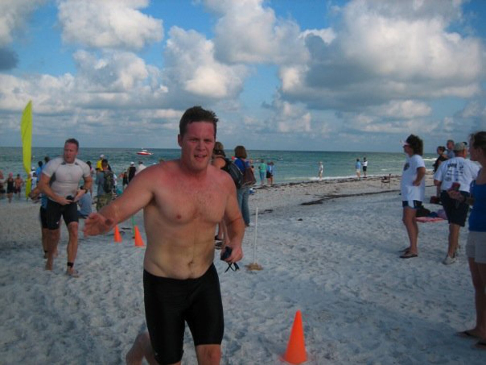 Capt Adam Uhan of the 63rd Air Refueling Squadron at Macdill Air Force Base waves to the crowd as he finishes the final leg of the Annual Dunedin Triathalon at Honeymoon Island.