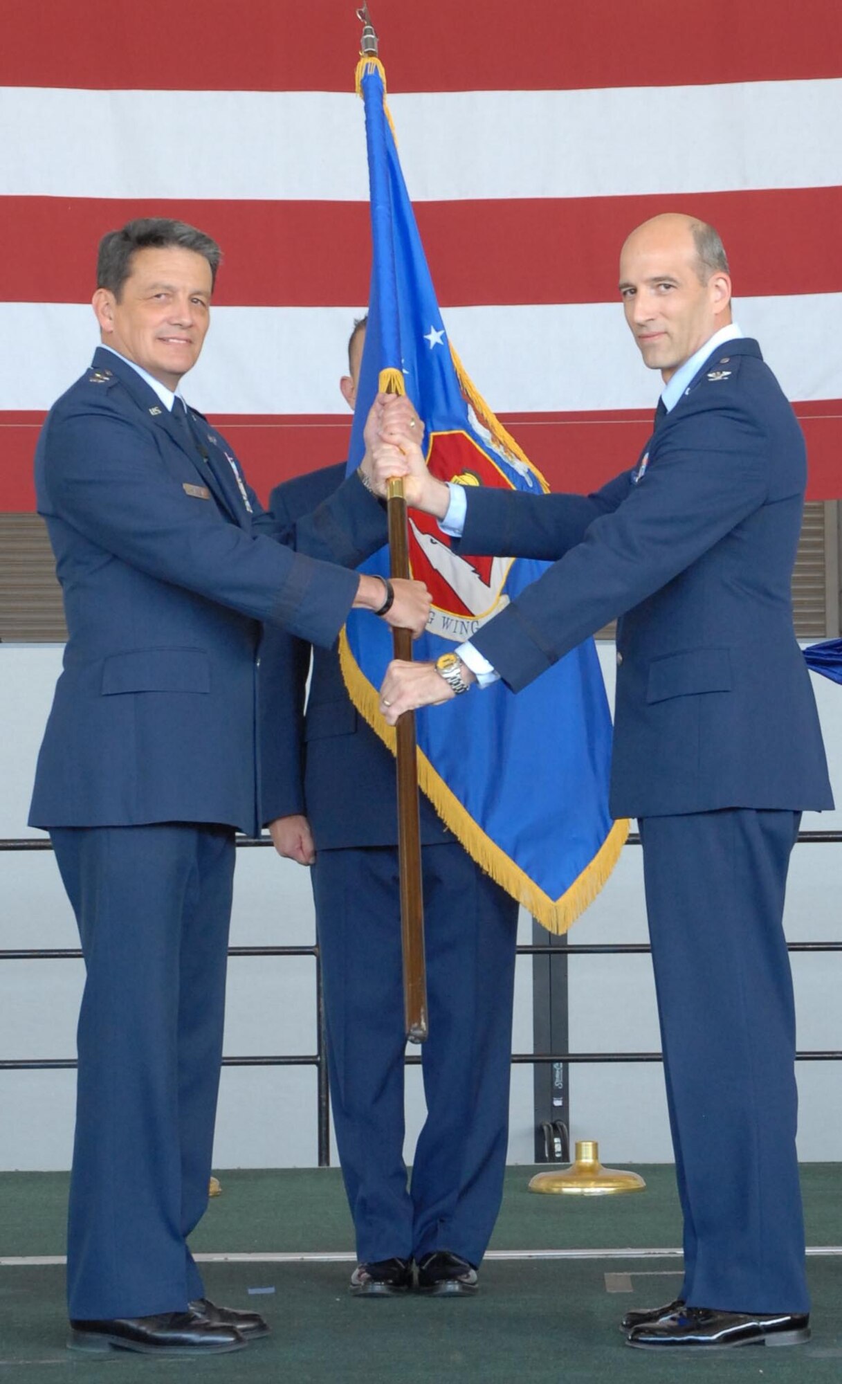 Maj. Gen. Frank Padilla, 10th Air Force commander, left, and Col. Jeffrey Mineo, 940th Wing commander, display the new 940th Wing flag during the 940th re-designation ceremony July 11. The ceremony officially deactivated the 940th Air Refueling Wing and stood up the 940th Wing. (Photo by Tech. Sgt. Luke Johnson) 

