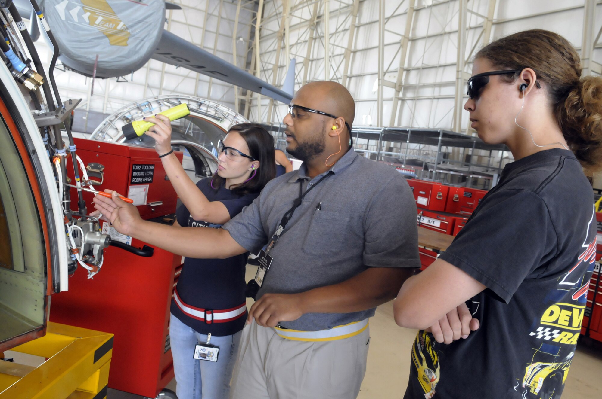 Jeffrey Williams, center, C-17 Aircraft overhaul supervisor, shows Heather Kearns, Perry High School senior, and Ryan Fenimore, Houston County High School senior,how an inspection is done on a C-17 engine thrust reverser to check for cracks, leaks and wear and tear. U. S. Air Force photo by Sue Sapp