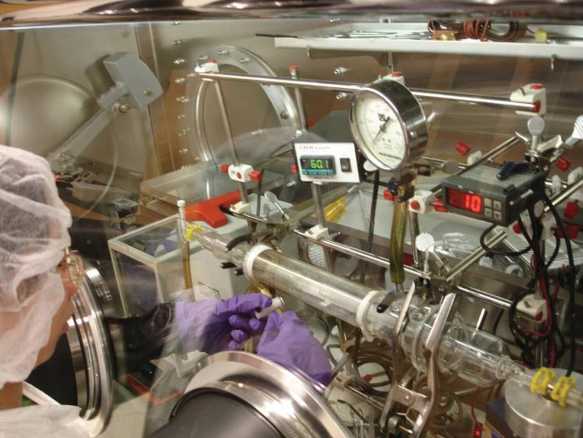 Student Chia-Yi Chen sets up a custom-designed, custom-built chemical vapor deposition(CVD) reactor inside a “glove box”, which maintains the nearly pure environment necessary for successful CVD to occur.  Image courtesy of A.J. Epstein, Ohio State University.