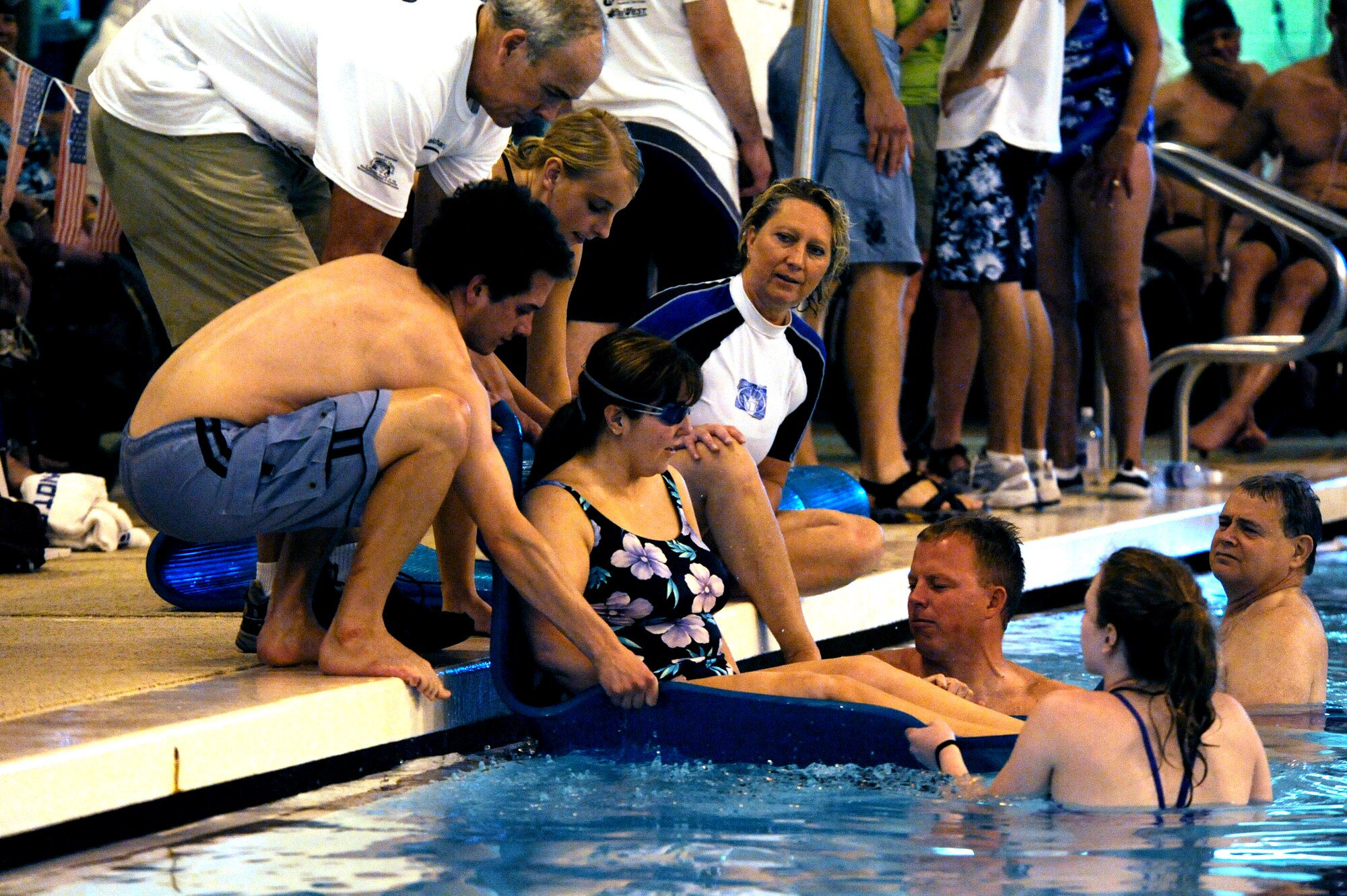 Terri Fuda is assisted by volunteers into the water before she competes in the swimming competition held at the Whitworth University swimming pool during the 29th National Veterans Wheelchair Games July 15 in Spokane, Wash. Ms. Fuda is an Air Force veteran from Gillespie, Ill. (U.S. Air Force photo/Staff Sgt. Desiree N. Palacios)