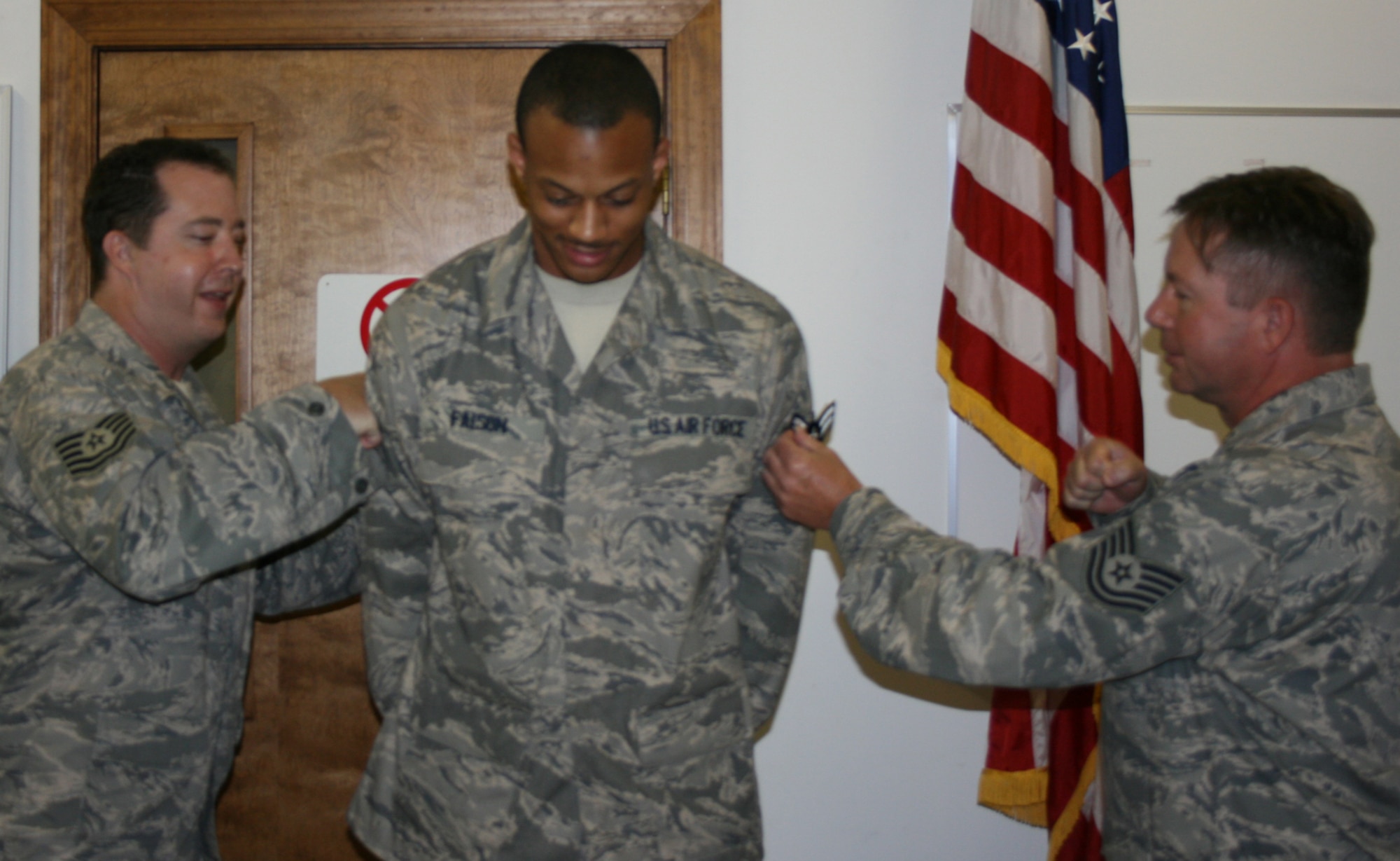 SEYMOUR JOHNSON AIR FORCE BASE, N.C. -- Reservist Desmond Faison (center) receives his promotion from the rank of airman to airman first class during the 916th Communication Squadron's drill weekend. Pinning on his stripes are Tech. Sgt. Michael Burbank and Kevin Howard.