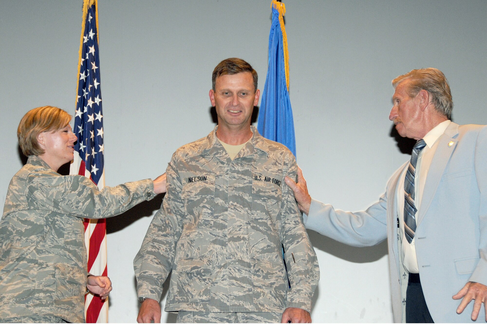 Lt. Col Brown and Mr. Roger Nelson tack on chief master sgt. stripes onto the new 916th Air Refueling Wing command chief, Chief Master Sgt. Gregory A. Nelson during commander's call July 11, at Seymour Johnson AFB, N.C.  (Photo by TSgt. Gillian M. Albro, 916th ARW/PA)