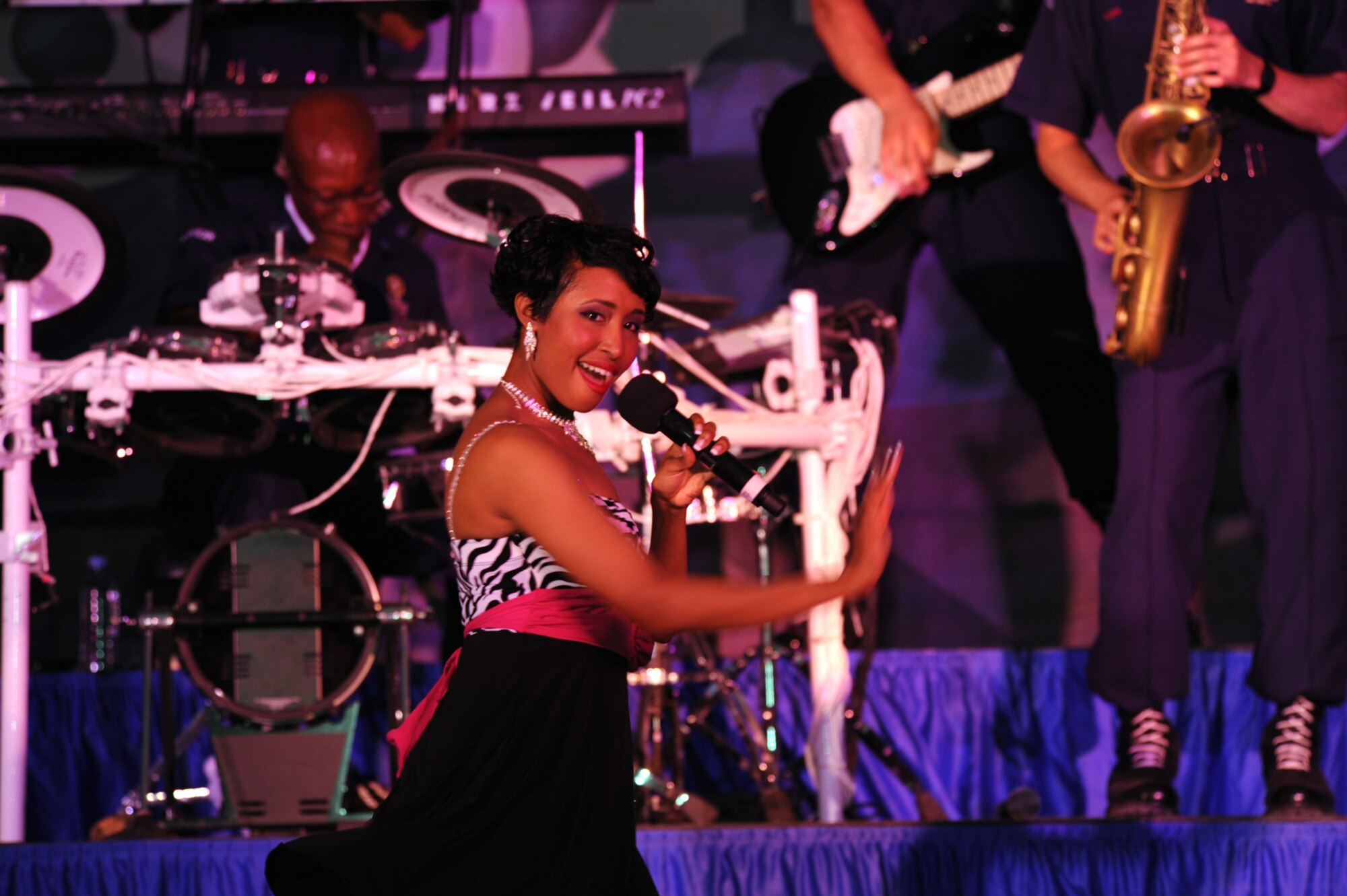 Staff Sergeant Aisha Smith, Tops in Blue vocalist, performs for an audience of deployed U.S. and coalition forces in Southwest Asia, July, 14. Tops in Blue serves as an expeditionary entertainment unit that provides quality entertainment from within Air Force resources to personnel stationed worldwide at remote and deployed locations while simultaneously promoting community relations, supporting recruiting efforts and serving as ambassadors for the United States. Sergeant Smith, a native of Richmond, Va., is a public health craftsman with the 6th Aerospace Medicine Squadron at MacDill AFB, Fla. (U.S. Air Force Photo/Staff Sgt. Robert Barney)