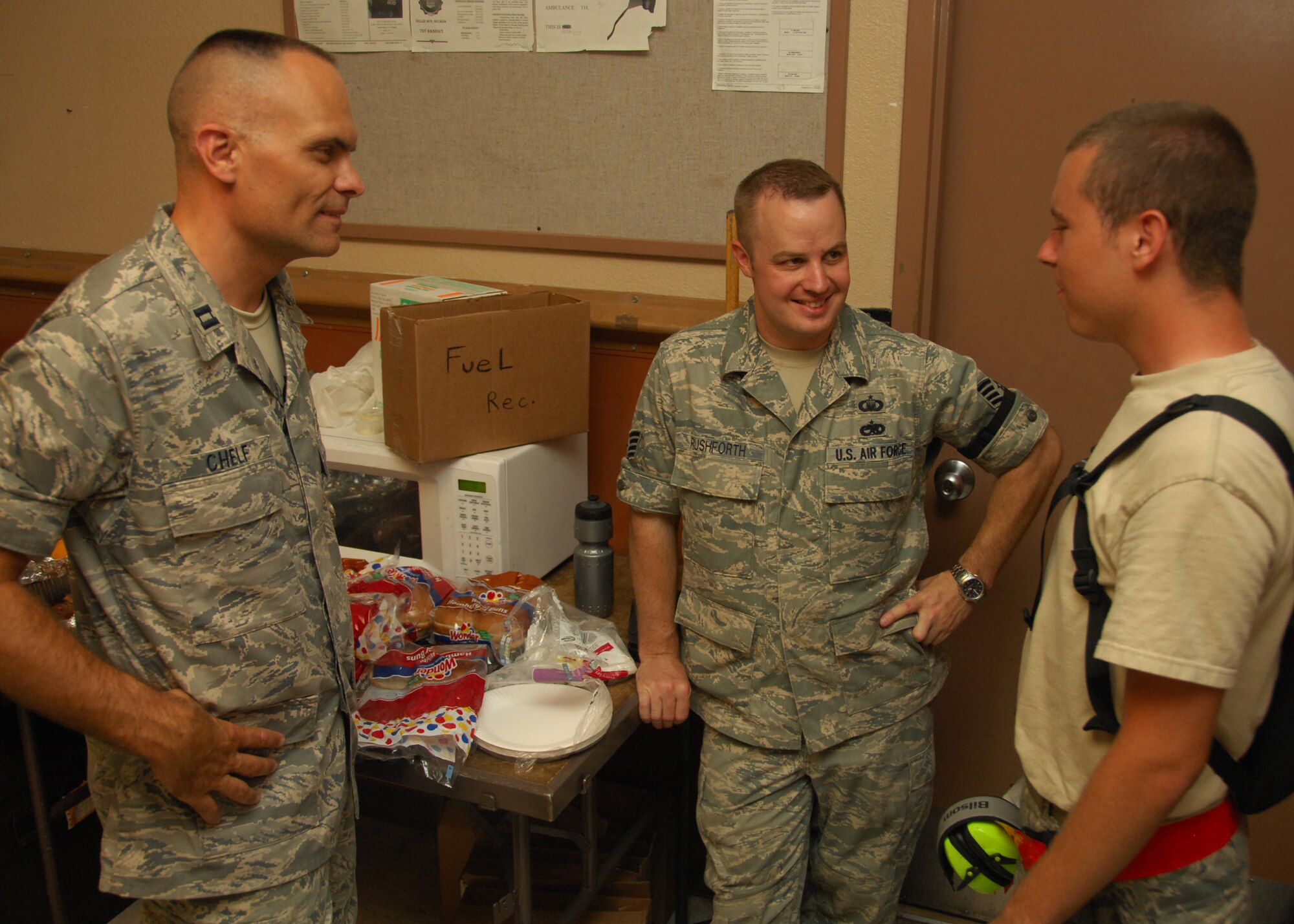 NELLIS AIR FORCE BASE, Nev. -- After serving lunch to Red Flag maintainers, Chaplain (Capt.) Kevin Chelf, and Staff Sgt. Shane Rushforth, chaplain's assistant, both from the 20th Fighter Wing at Shaw Air Force Base, S.C., talk maintenance with Airman 1st Class Derek Orawiec. (U.S. Air Force photo/2nd Lt. Emily Chilson)
