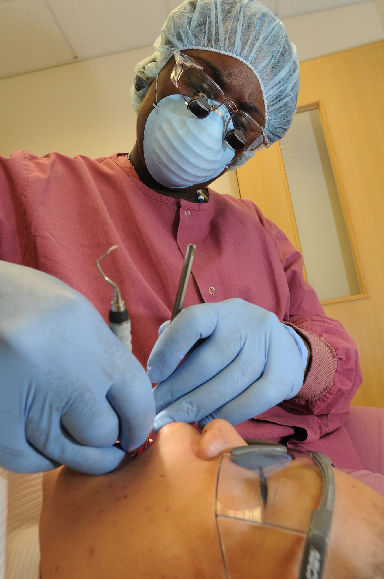 Tech. Sgt. Vicki Johnson performs a scaling and root planning procedure on a patient at RAF Lakenheath, June 14, 2009. She is a registered dental hygienist with the 48th Dental Squadron. She specifically works for the Periodontal Department, which provides care for a patient?s gums and bones. The care could be anything from gum disease to reconstructive surgery to improve smiles and aid in crowns and bridges. (U.S. Air Force photo by Staff Sgt. Nathan Gallahan)