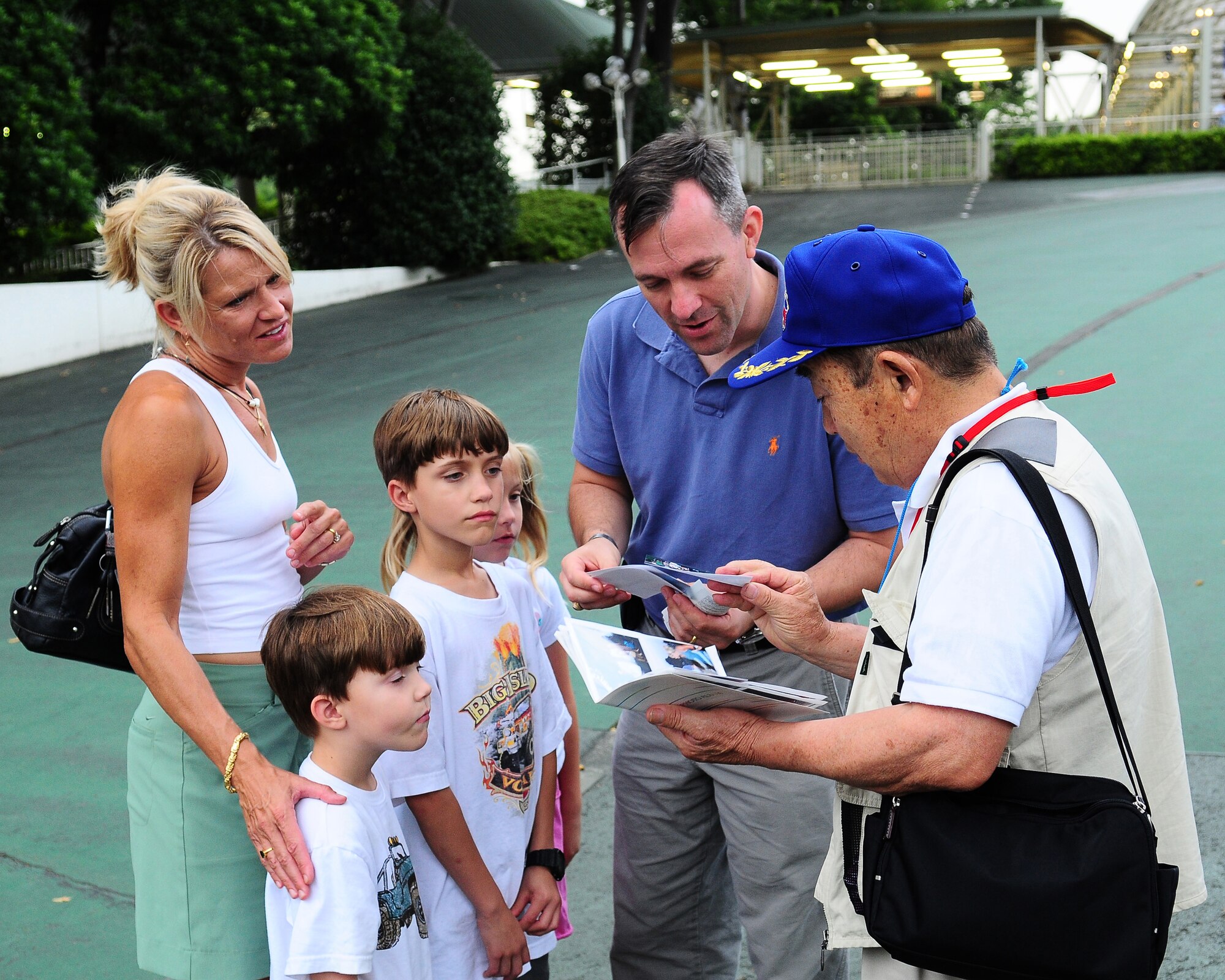 TOKOROZAWA, Japan -- Lt. Col. Robert McCrady, 374th Operations Group deputy commander, and his family look at photos with Shosuke Ito, president of the Musashimurayama Yokota Friendship Club July 14 prior to a Japanese Baseball League game between the Saitama Seibu Lions and the Tohoku Rakuten Golden Eagles at the Seibu Dome. The club treated more than 30 members of the operations group to the game. The club hosts several events throughout the year to strengthen the relationship between the two communities. (U.S. Air Force photo/Airman Sean Martin)