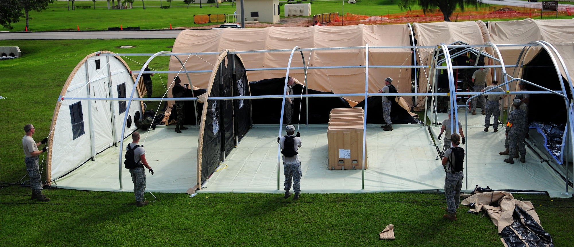 ANDERSEN AIR FORCE BASE, Guam - The 36th Medical Group and the 36th Contingency Response Group work together to construct operational tents during a simulated exercise for the Humanitarian Assistance Rapid Response Team here July 15. The HARRT is equipped to operate in an austere permissive environment during Phase III of disaster relief operations, supporting 350 to 500 patients per day and can be fully operational within six hours of arrival at the disaster site. (U.S. Air Force photo by Airman 1st Class Courtney Witt)