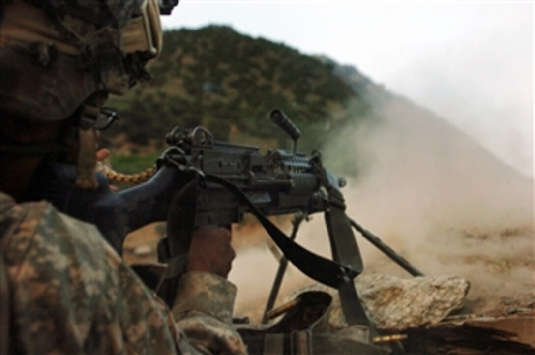 A U.S. Army soldier with 1st Battalion, 32nd Infantry Regiment, 10th Mountain Division fires at opposing forces attacking from the hills surrounding the remote village of Barge Matal during Operation Mountain Fire in Nuristan province, Afghanistan, on July 12, 2009.  During the operation, U.S. and Afghan National Security Forces quickly secured the tiny mountain village.  