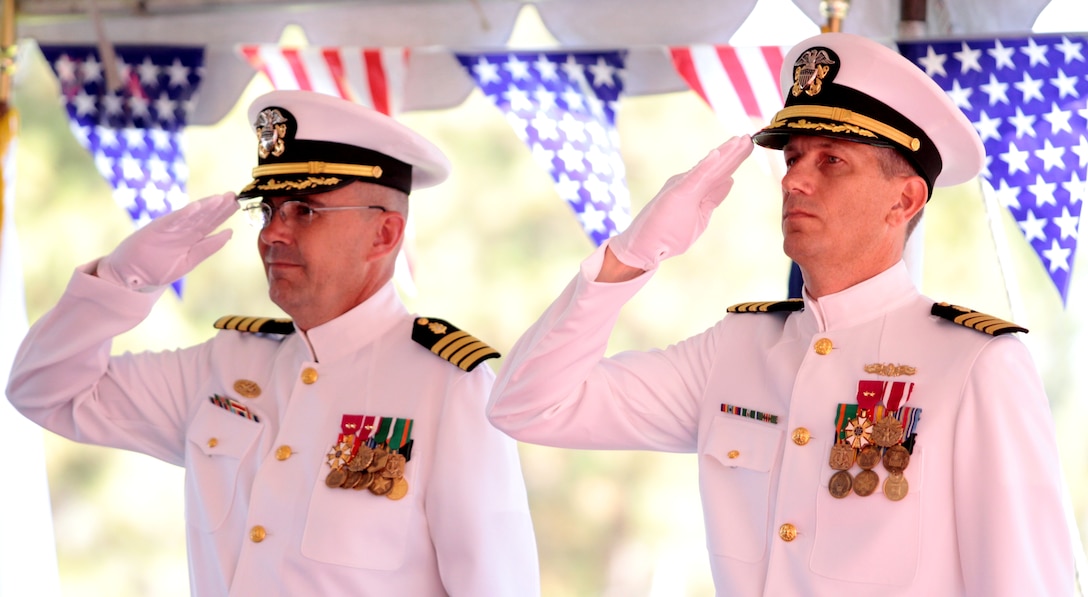 Navy Capt. C. Forest Faison III and newly appointed commander of Naval Hospital Camp Pendleton, Navy Capt. Paul D. Pearigen, salute during the national anthem during a change of command ceremony, July 17.