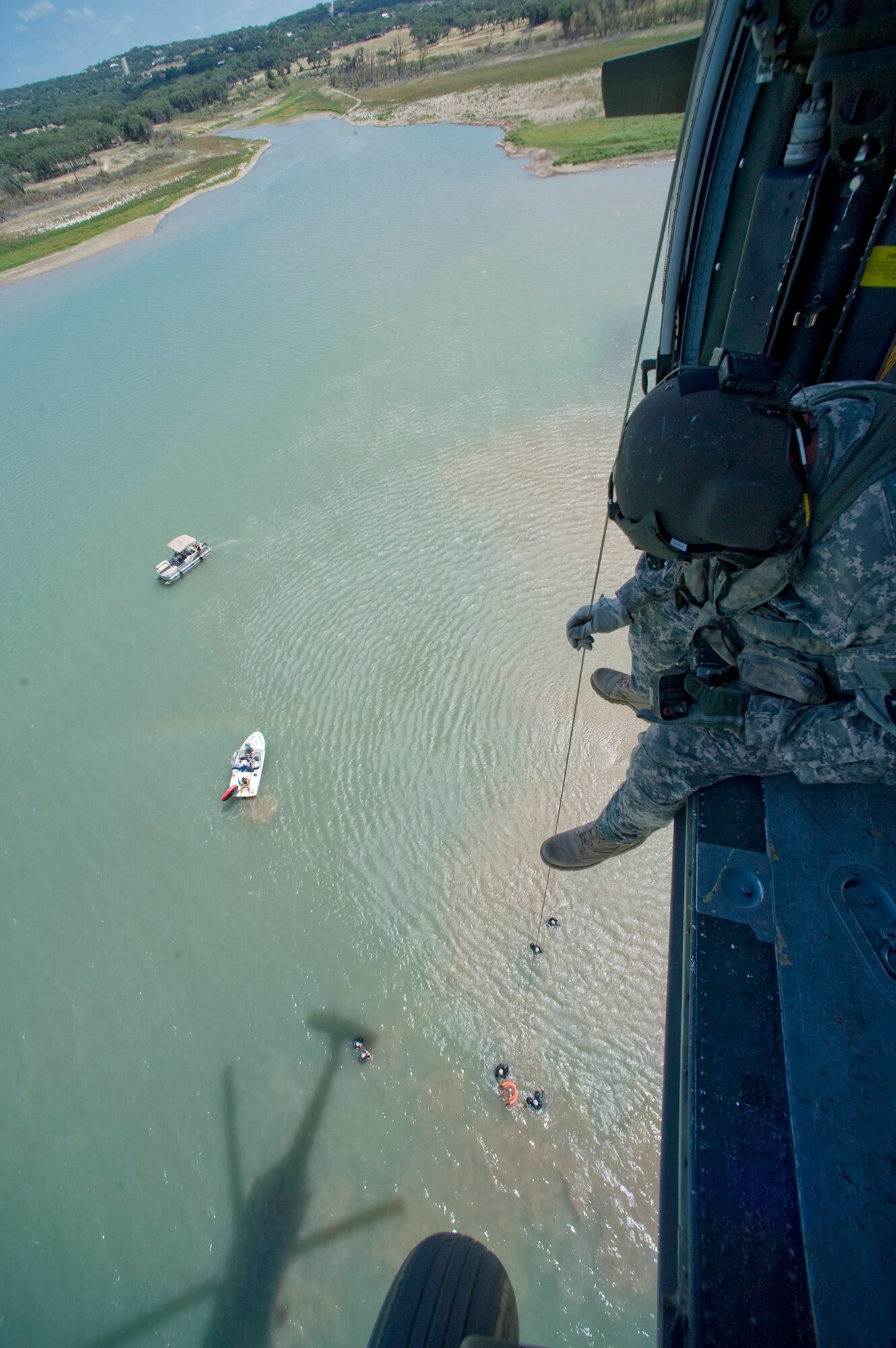 U.S. Army Sgt. Teddy Cole lowers a water rescue basket during refresher aircrew water survival training at Canyon Lake, Texas. Sergeant Cole is a UH-60 Black Hawk crew chief assigned to the 149th Aviation Regiment in San Antonio. The refresher training was conducted for members of the 149th Fighter Wing also based in San Antonio. Both units belong to the Texas National Guard. (U.S. Air Force photo/Master Sgt Jack Braden)