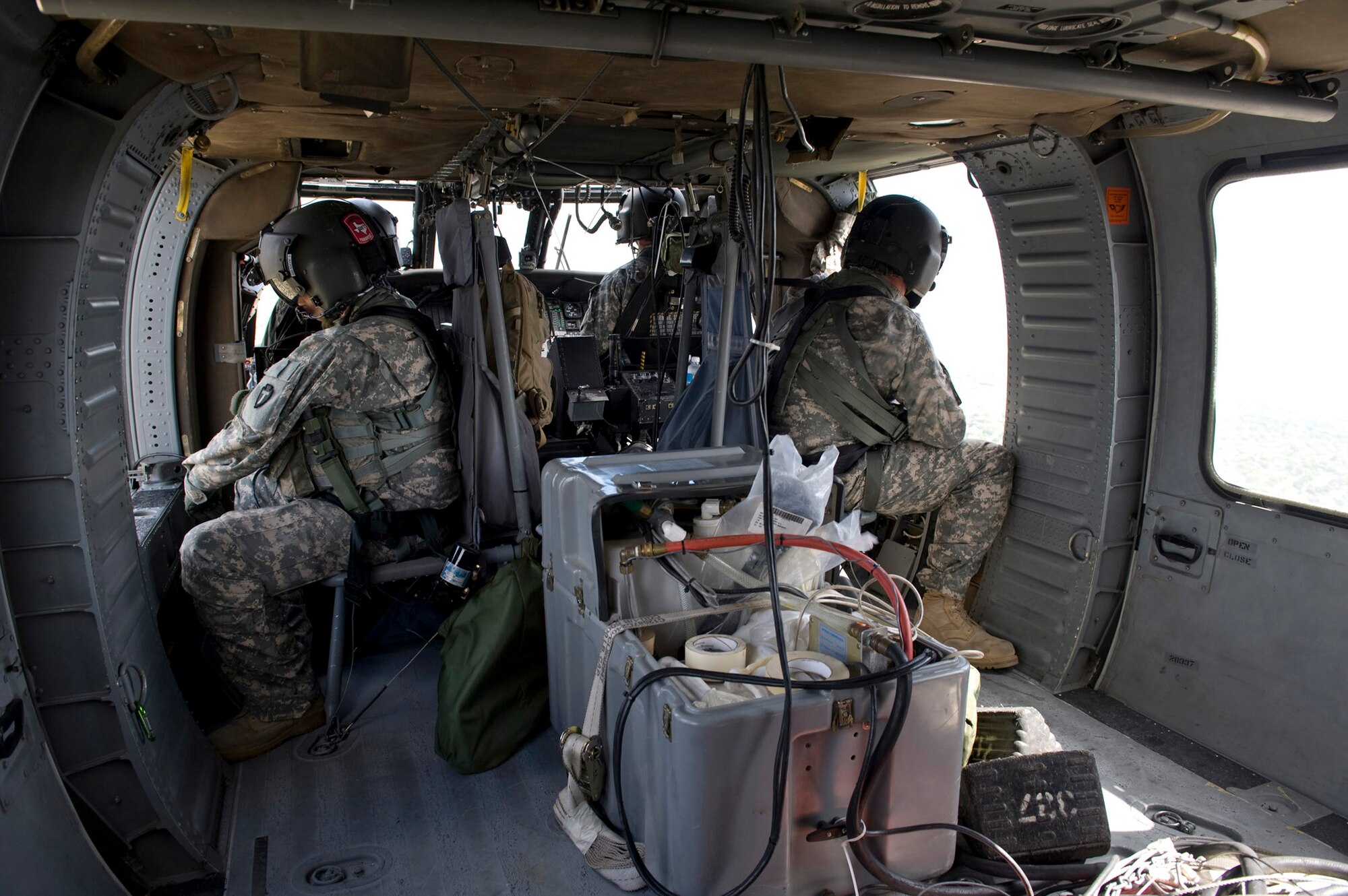 U. S. Army Sgts. Teddy Cole, crew chief, (right) and Kenneth Jarrett, flight medic, watch for hazards during a flight to provide air support for refresher aircrew water survival training. Both are assigned to the Texas Army National Guard's 149th Aviation Regiment in San Antonio. (U.S. Air Force photo/Master Sgt. Jack Braden)