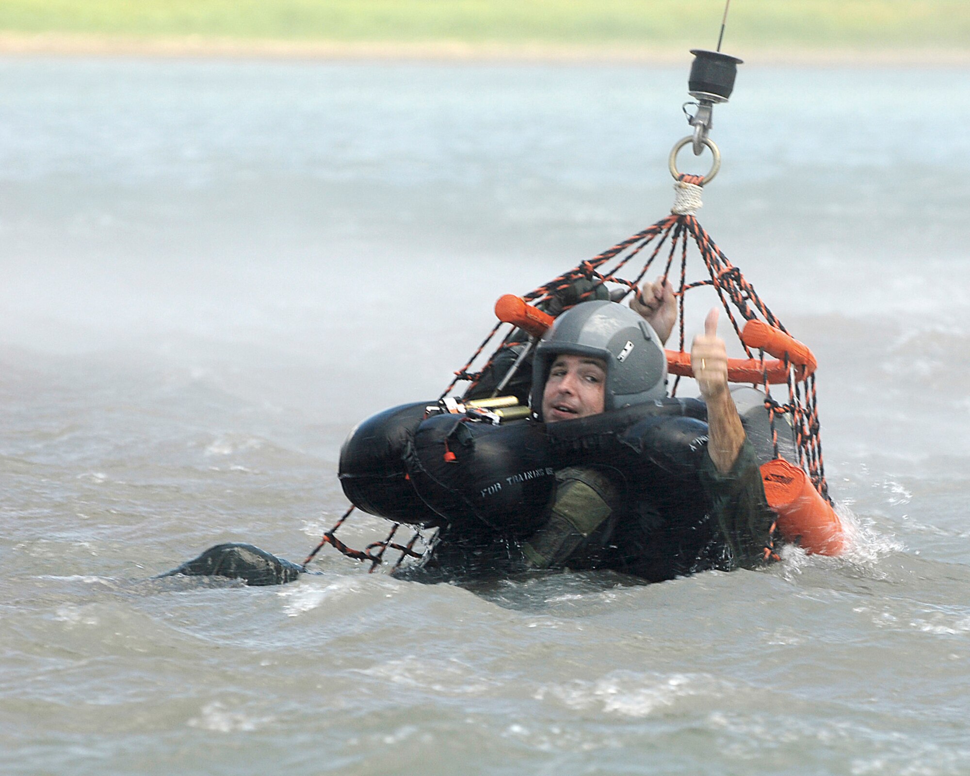 Maj. Michael Meylor, an F-16 Fighting Falcon pilot, gives thumbs up for extraction to the crew of an Army UH-60 Black Hawk helicopter during a water survival training exercise July 11 at Canyon Lake, Texas.  He is assigned to the Texas Air National Guard's 149th Fighter Wing at Lackland Air Force Base, Texas, and the refresher training is an annual requirement for aircrew members. (U.S. Air Force photo/Master Sgt. Robert Shelley) 
