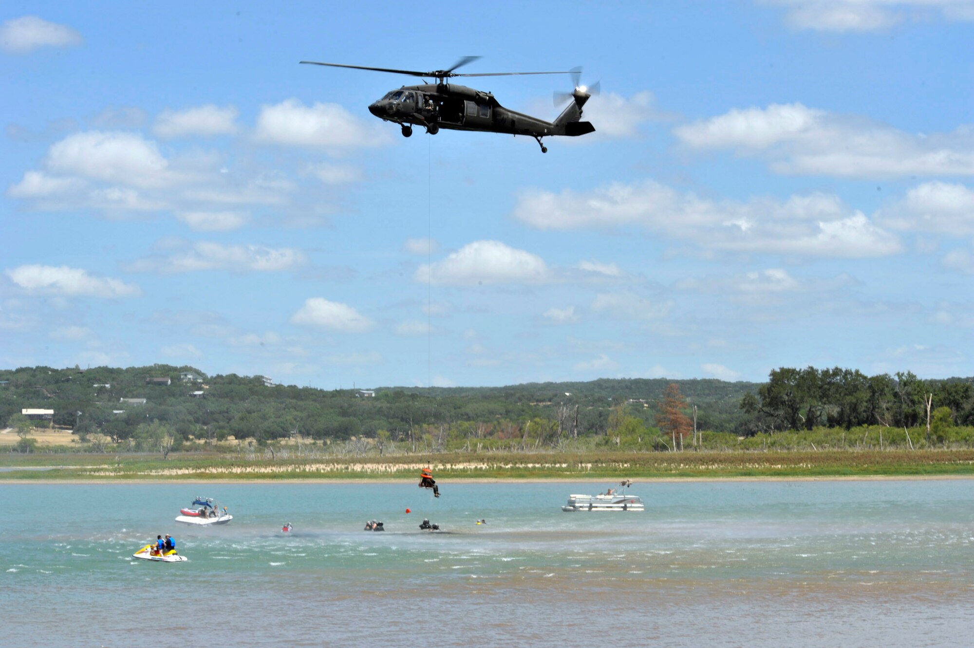 A UH-60 Black Hawk from the 149th Aviation Regiment is maneuvered in to position during refresher aircrew water survival training at Canyon Lake near San Antonio. The aircraft and crew provided the water recovery portion of the refresher training conducted by the 149th Fighter Wing. Both units are part of the Texas National Guard assigned in San Antonio.( U.S. Air Force photo/Master Sgt. Jack Braden) 
