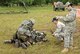 Two Exercise Evaluation Team members look on as a “wounded” Airman receives care from another member. Self Aid and Buddy Care is one of the areas that are closely looked at during exercises designed to prepare Airmen for deployment. (Air Force photo by Margo Wright)