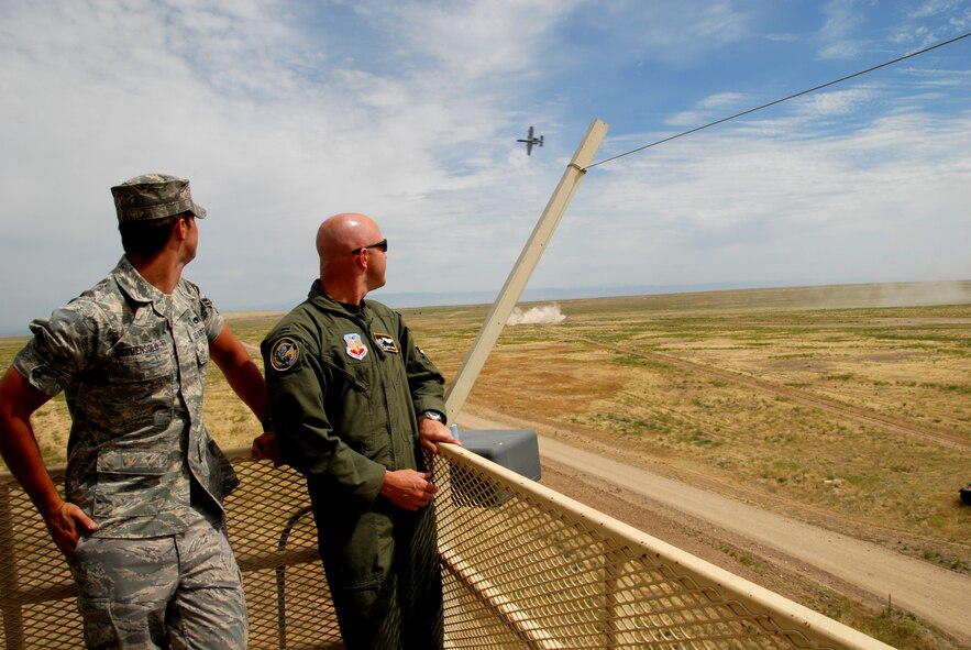 Airman First Class Christopher Bermensolo and 1st Lieutenant Jeremy Presley from the Idaho Air National Guard watch as an A-10 aircraft flies by shooting targets on the Saylor Creek target range on July 11, 2009. Both members of the IDANG were impressed by the high speed and accuracy of the A-10 aircraft and 190th Fighter Squadron pilots. (Air Force photo by Tech Sgt Becky Vanshur)(Released)