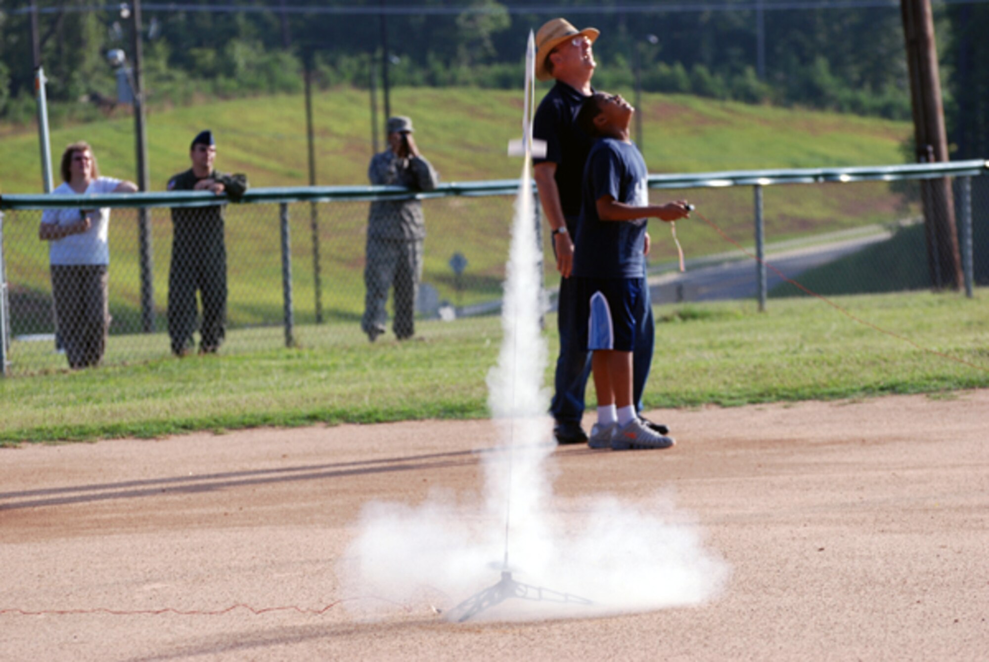 Chief Master Sgt. (ret.) Jim Jackson, STARBASE instructor, and a student fire off a rocket during the STARBASE camp at Dobbins Air Reserve Base July 16. The four-day program taught children of DoD members about science, math, technology and aviation. (U.S. Air Force photo/Kennith Green)