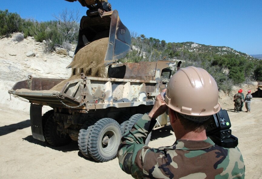 Master Sgt. Mike Townsend, a videographer with the 193rd Special Operations Wing, Middletown, Pa., films excavation efforts along the U.S. border with Mexico.  Members of the 201st REDHORSE Squadron worked for weeks improving infrasctructure near Campo, Calif. (Photo by Capt. Jay Ostrich)