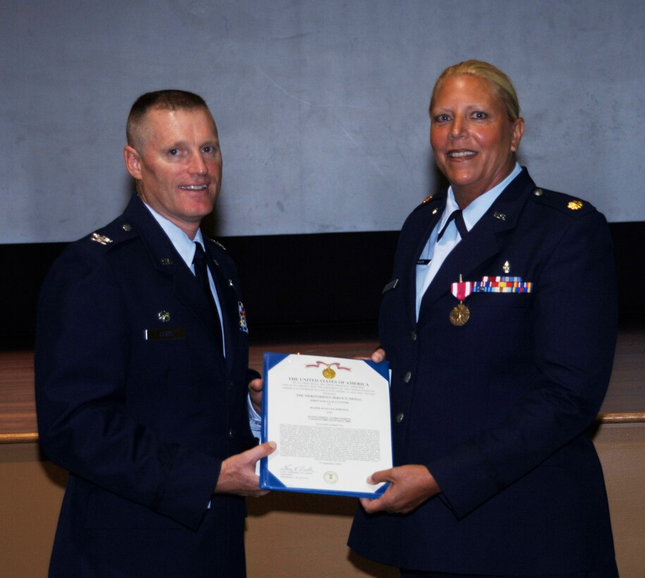 Maj Jo Ellen Johnson, 927th Air Refueling ASTS, accepts the Meritorious Service Medal from Wing Commander Colonel Kenneth D. Lewis, Jr at Commander's Call on July 12, 2009. (USAF PHOTO/Tsgt Denise Hauser)