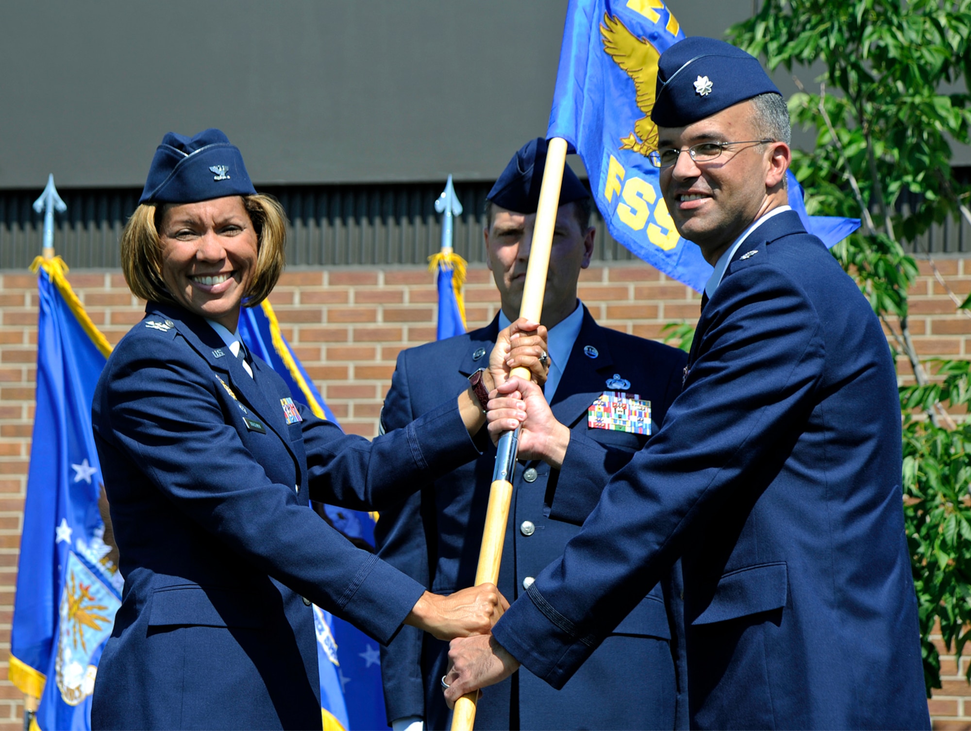 PETERSON AIR FORCE BASE, Colo. -- Col. Emily Buckman, 21st Mission Support Group commander, passes the 21st Force Support Squadron colors to Lt. Col. John Silverman, the new 21st Force Support Squadron commander, during a change of command ceremony July 15. Colonel Silverman arrives from Charleston Air Force Base, S.C., where he was the commander of the 437th Force Support Squadron, and replaces Lt. Col. Robert Romer, who leaves Peterson to join Headquarters U.S. Air Force A1 staff in Washington, D.C. (Air Force photo by Craig Denton)